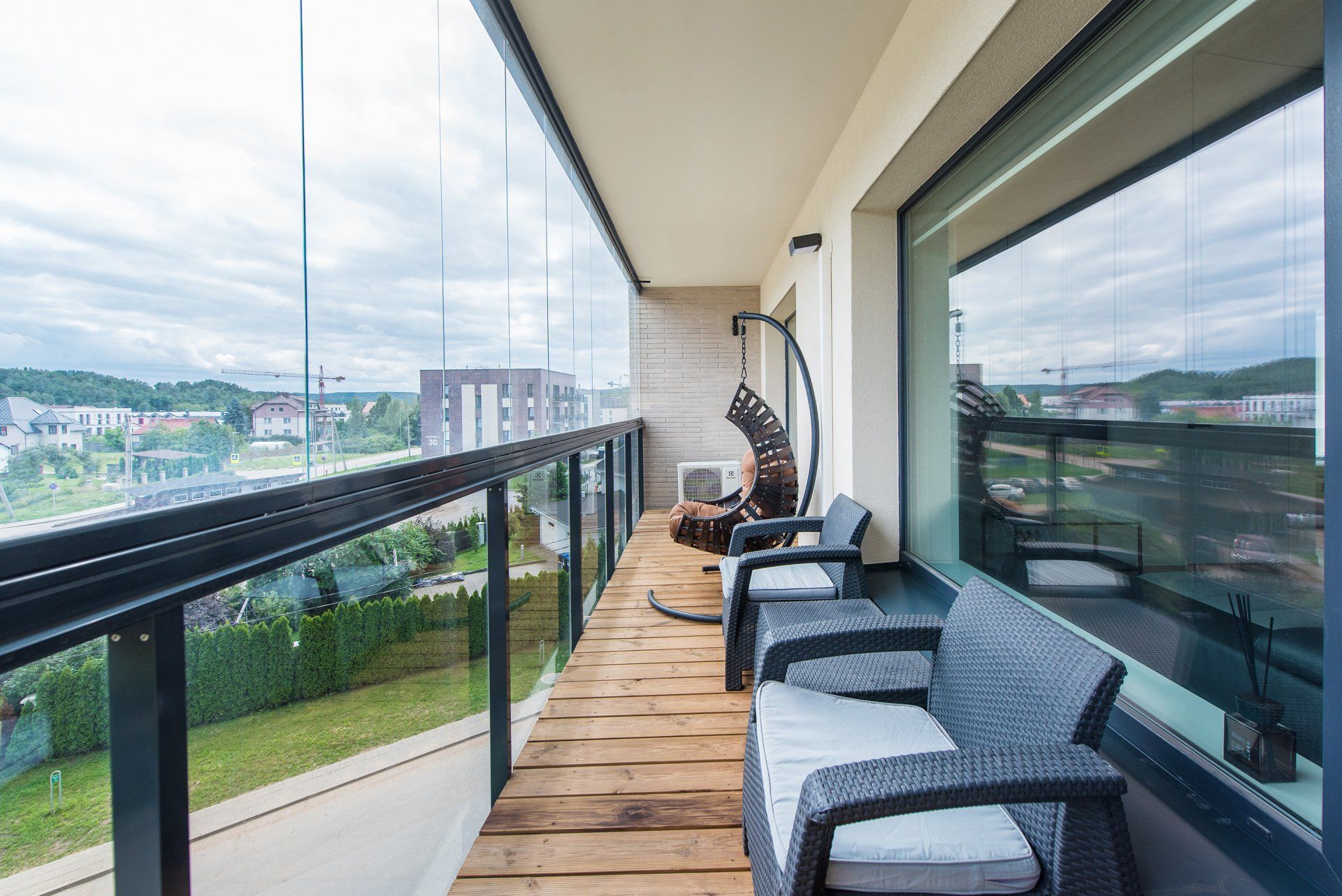 Balkonas su foteliais, sofa ir sūpynėmis.