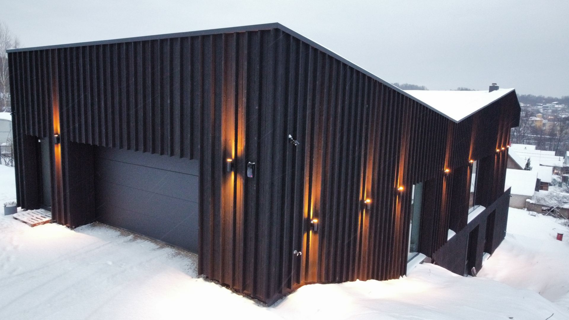 Namo su garažu sniege vaizdas iš oro.