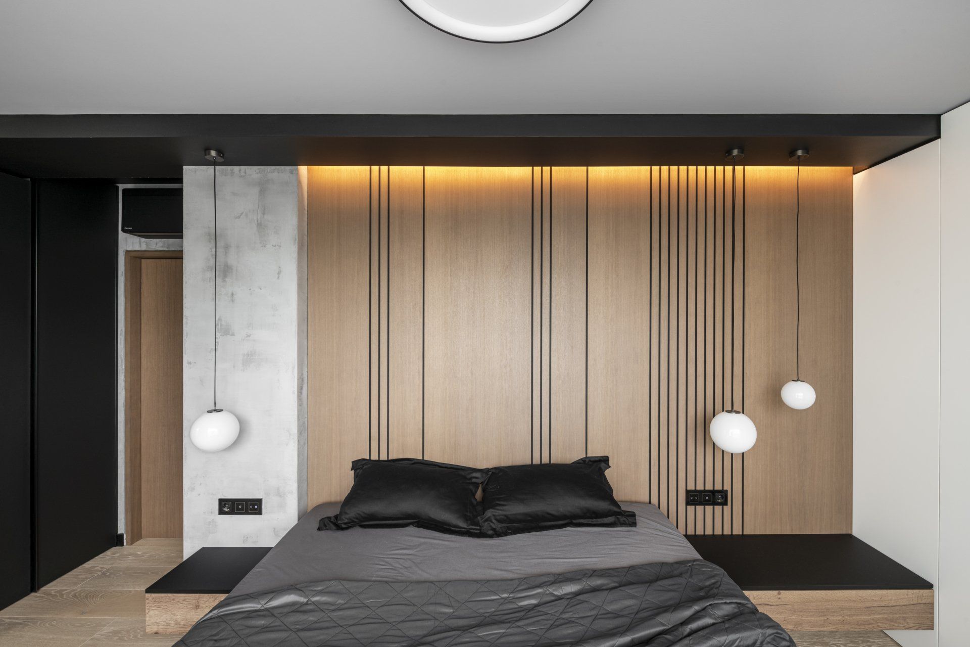 Kambario viduryje stovi lova, už kurios – medine siena.