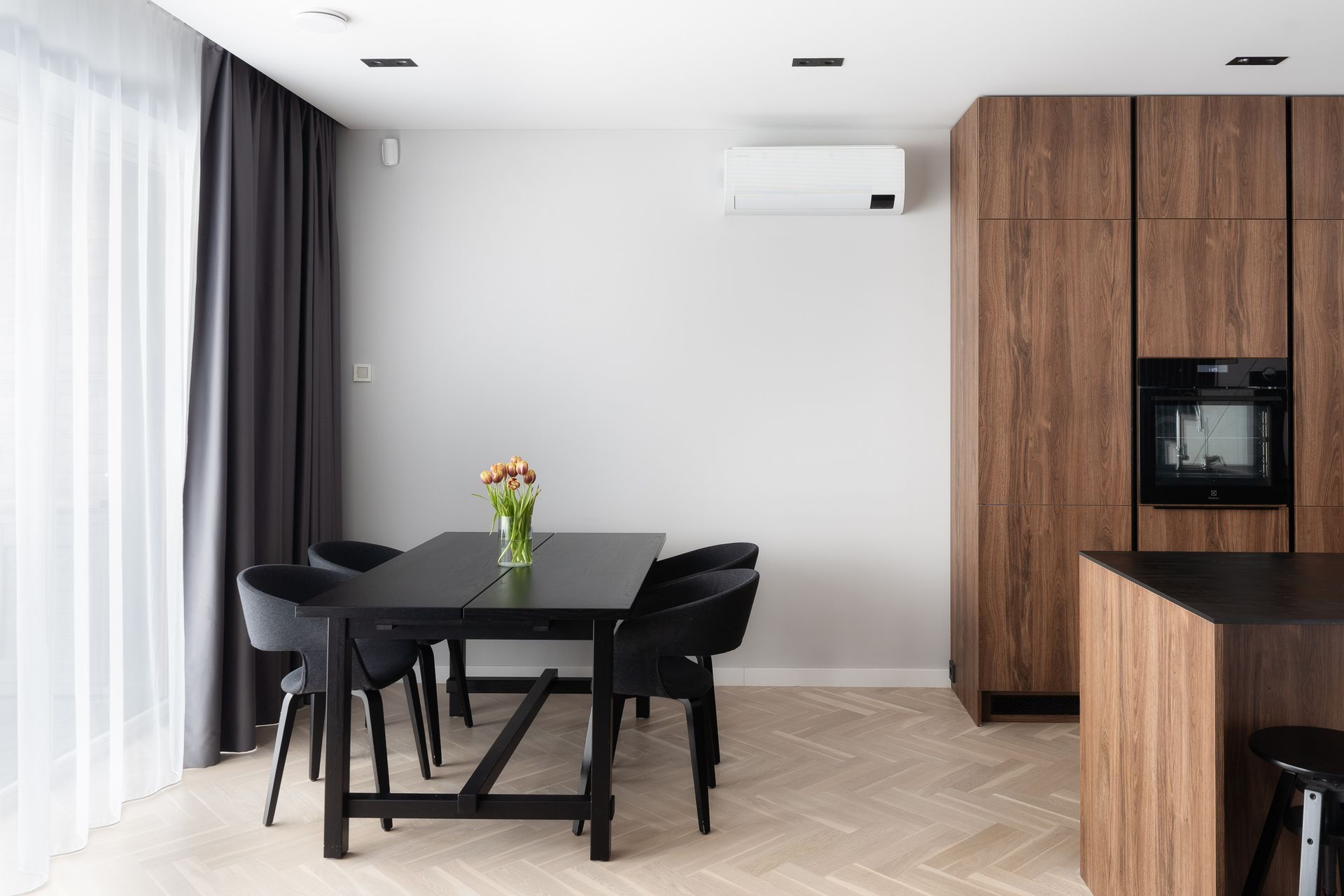 Kambario viduryje yra valgomojo stalas ir kėdės.