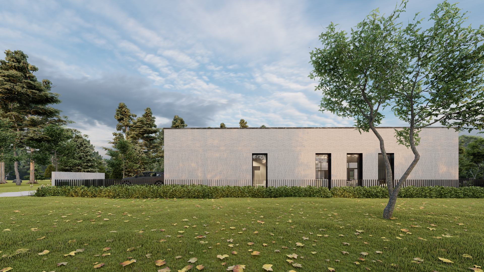 Didelis baltas namas stovi vešlios žalios pievos viduryje, apsuptas medžių.