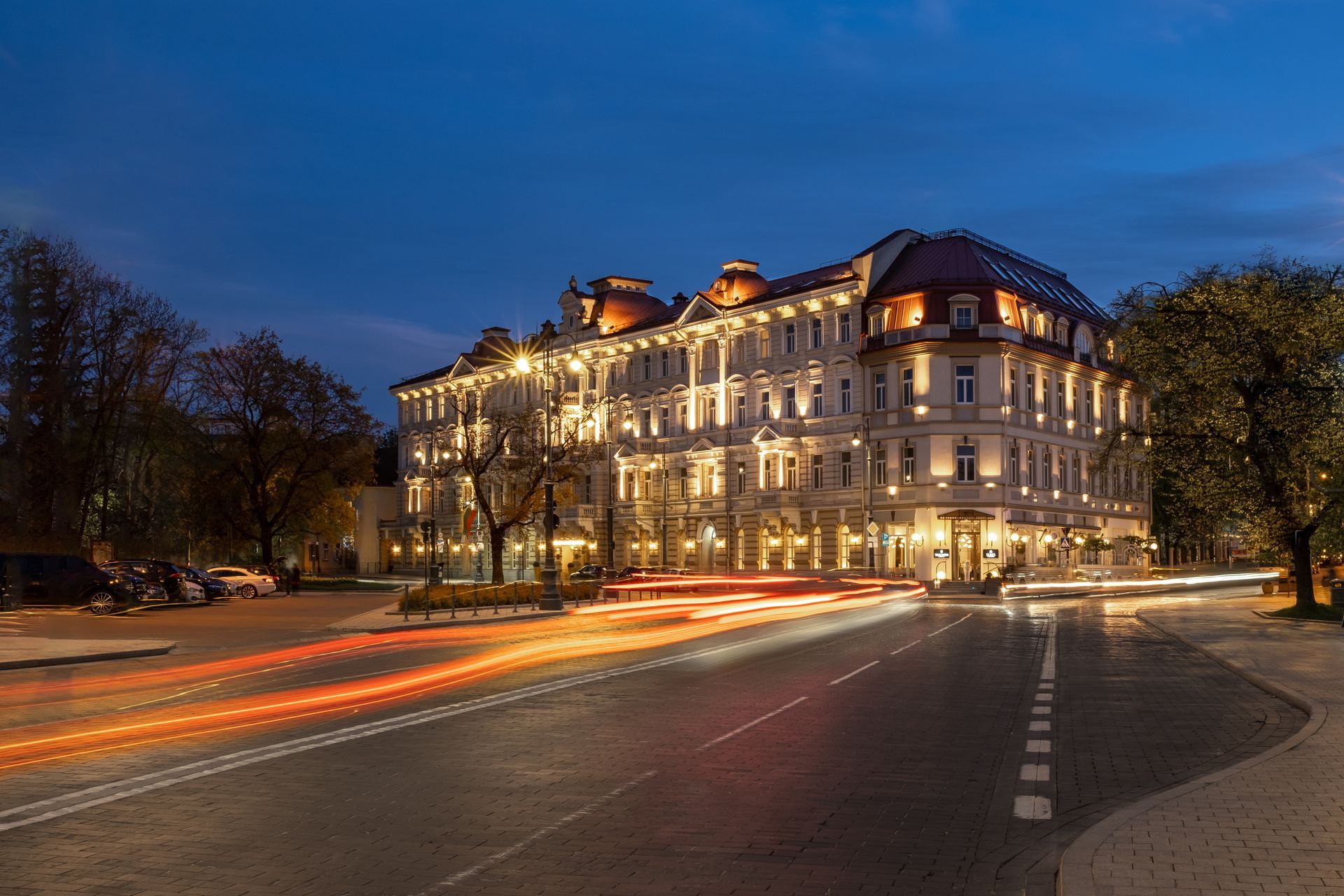 Naktį apšviestas didelis pastatas su daugybe šviesų.