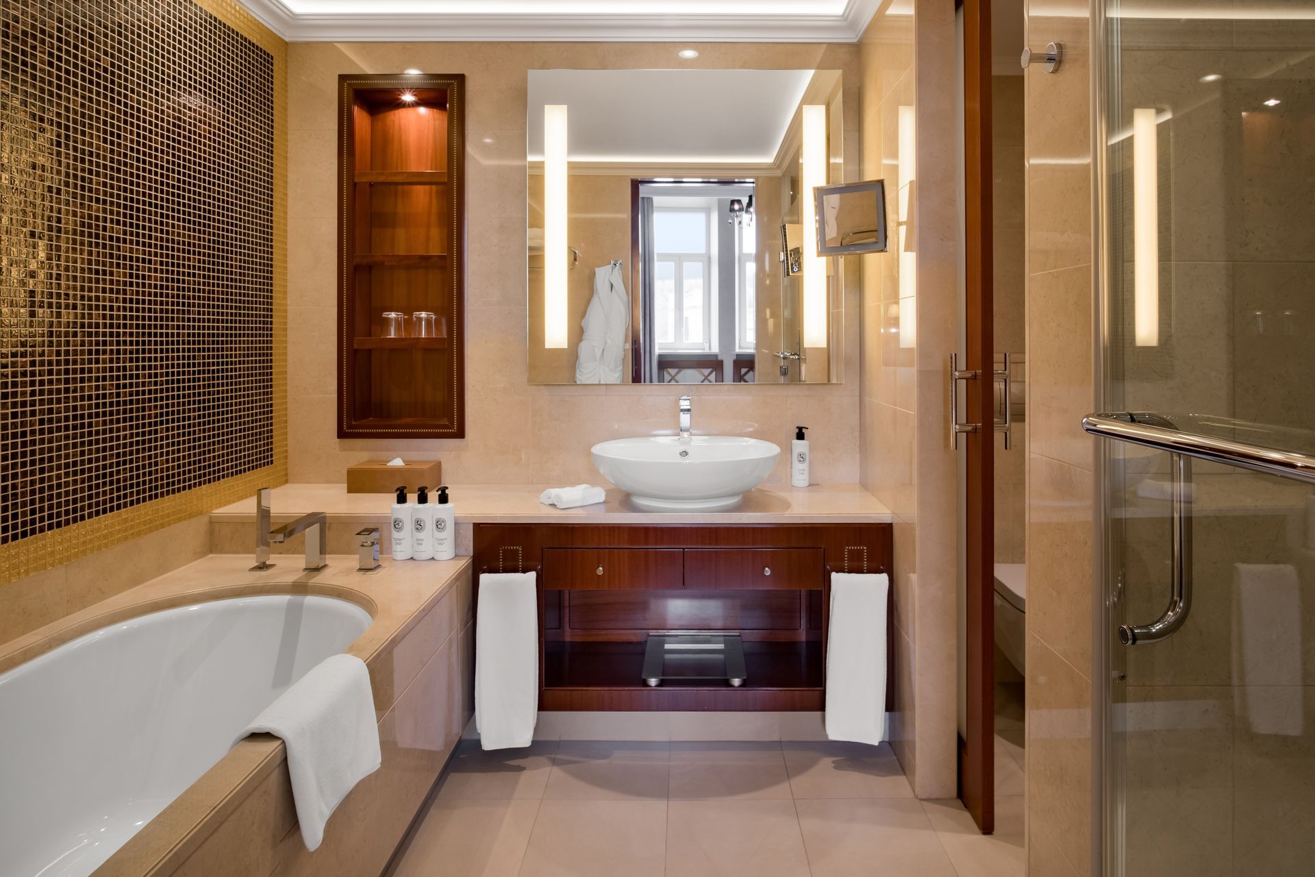 Vonios kambarys su vonia, kriaukle, veidrodžiu ir dušu.