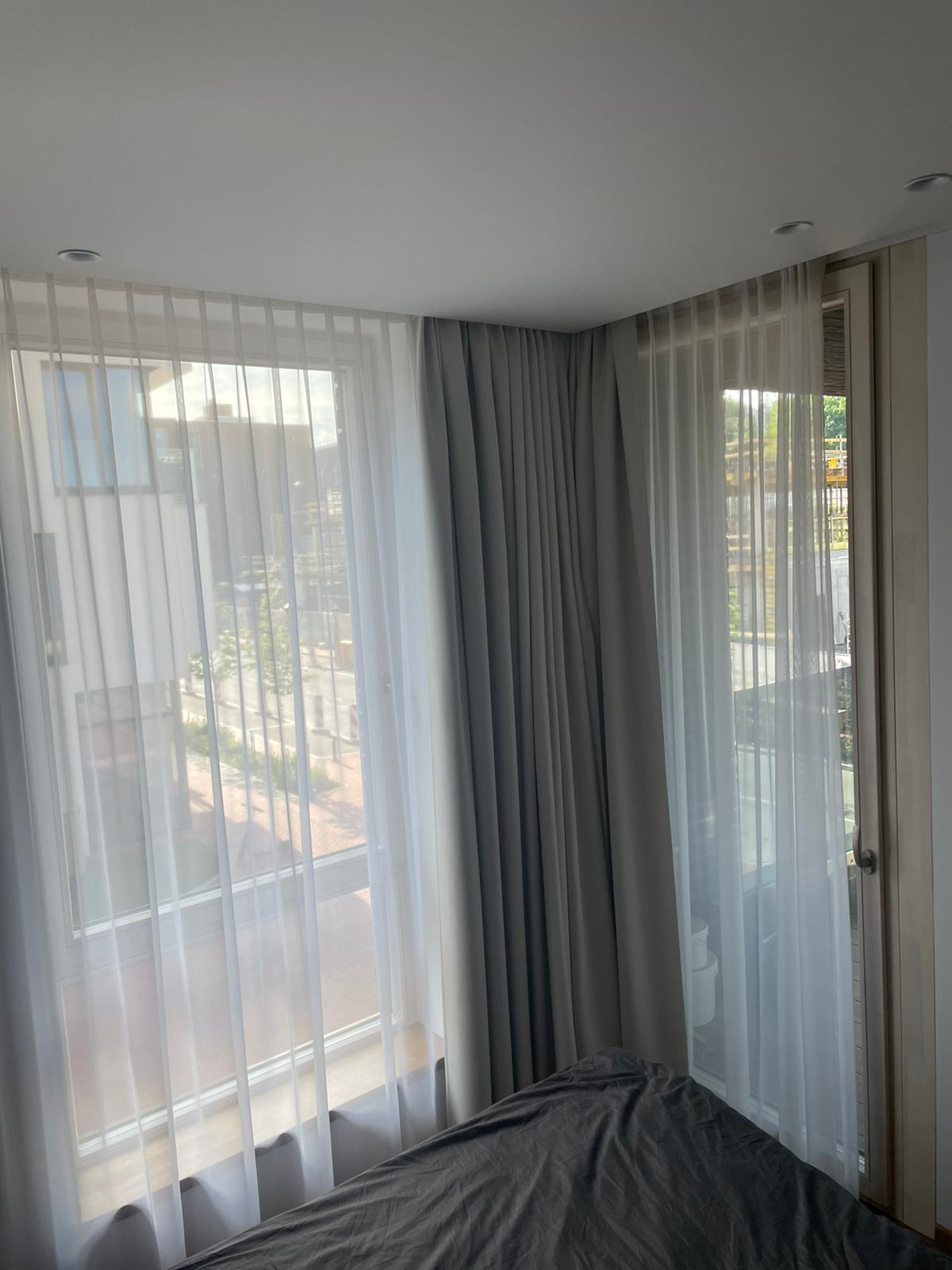 Miegamasis su lova, užuolaidomis ir langu.