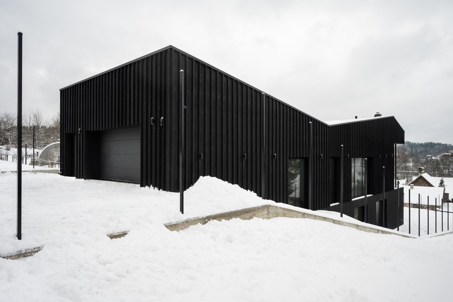 Naktį sniege apšviestas namas