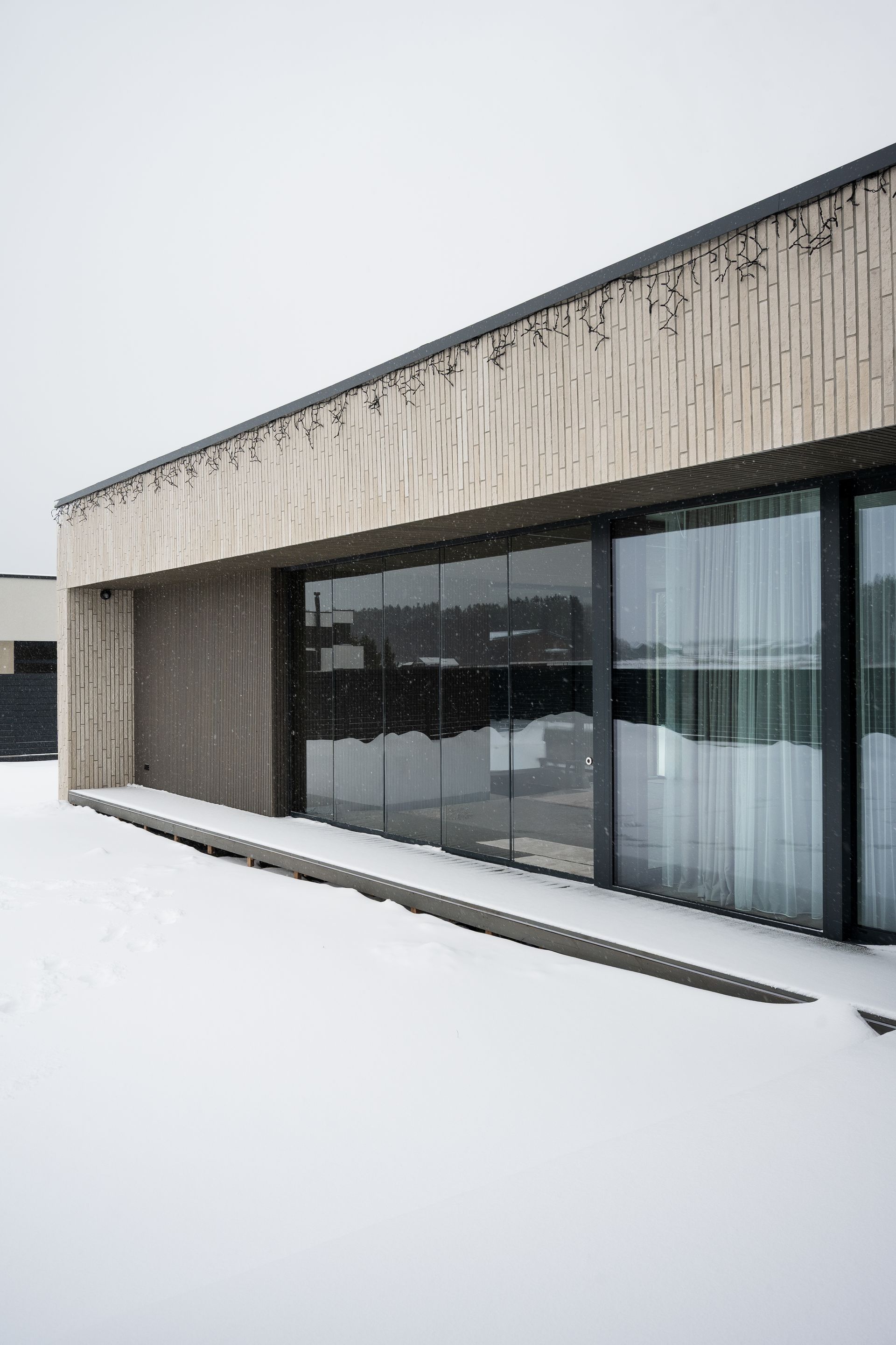 Modern building with large windows, covered in snow.