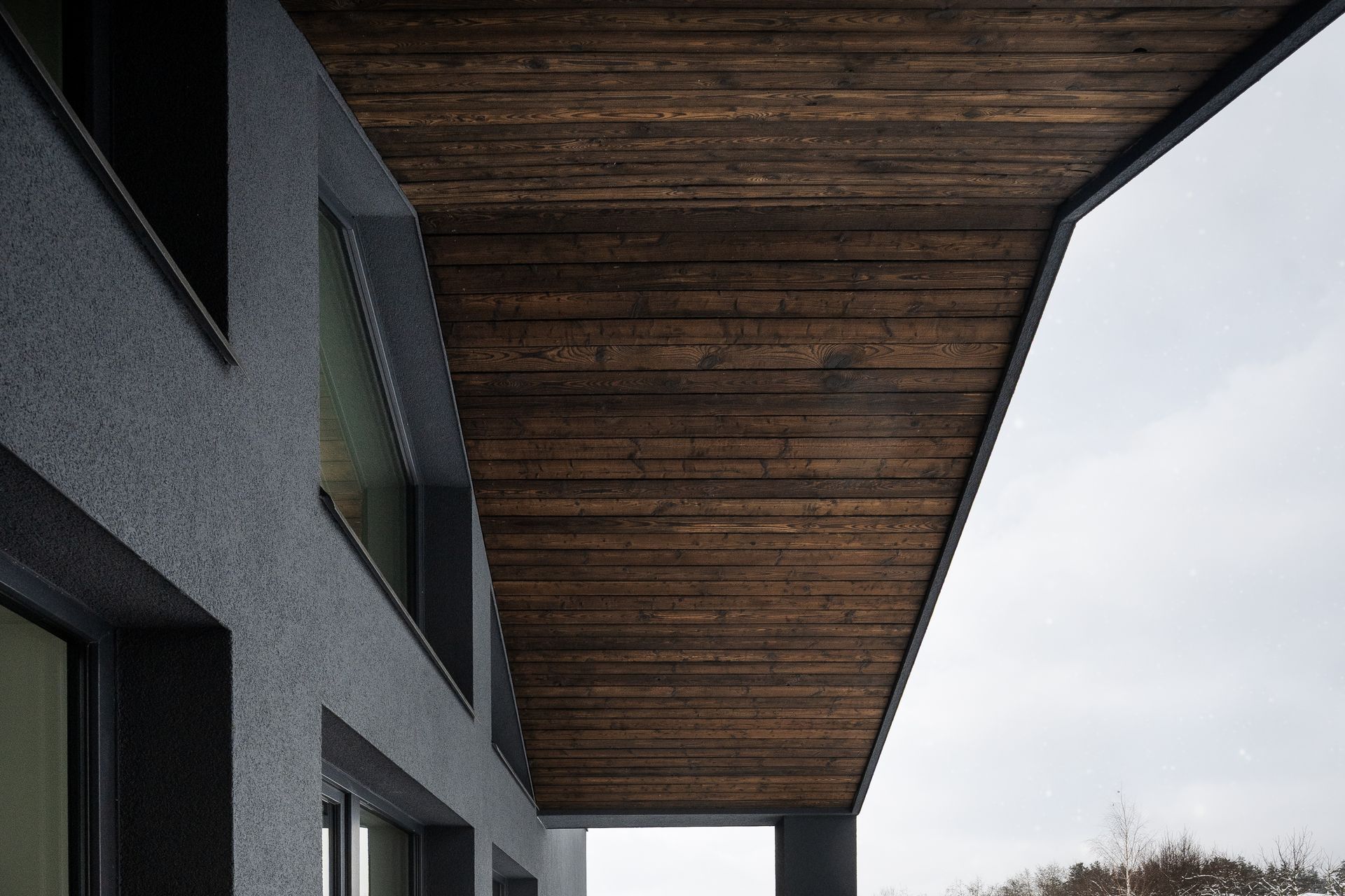 Dark building exterior with wooden ceiling overhang.