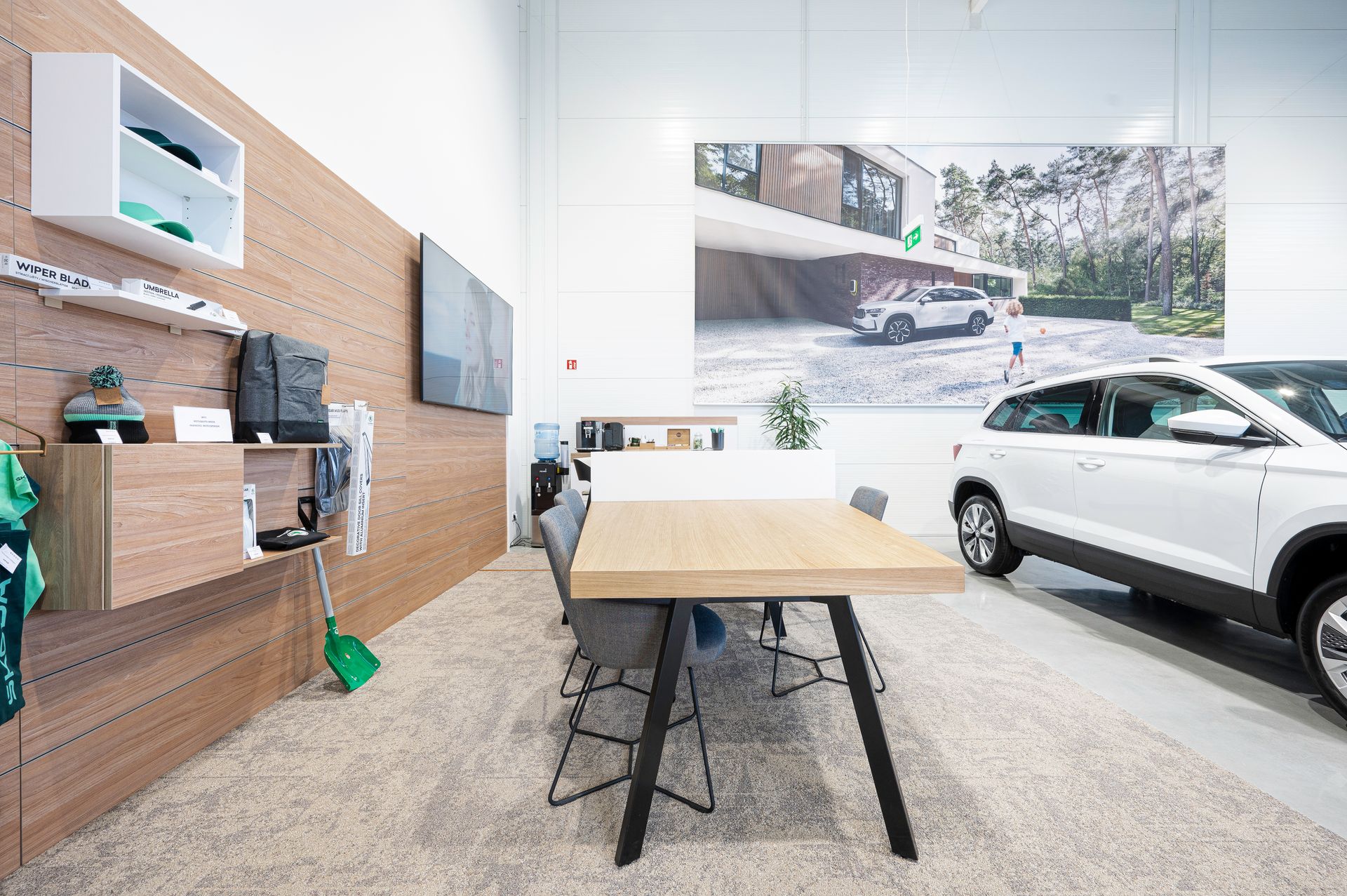 Kambarys su stalu, kėdėmis ir automobiliu fone.