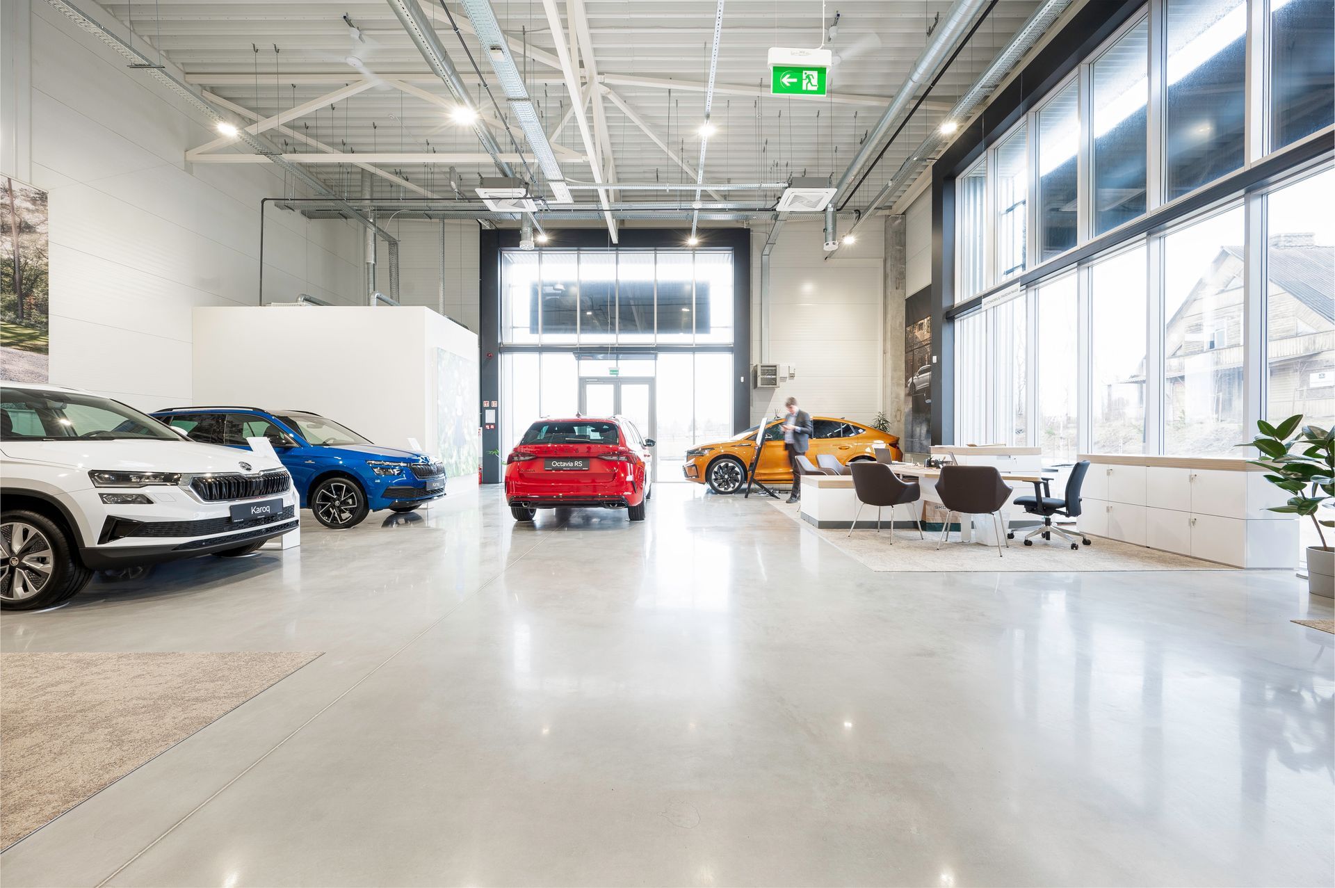 Salonas, pilnas automobilių ir daugybės vitrinų.