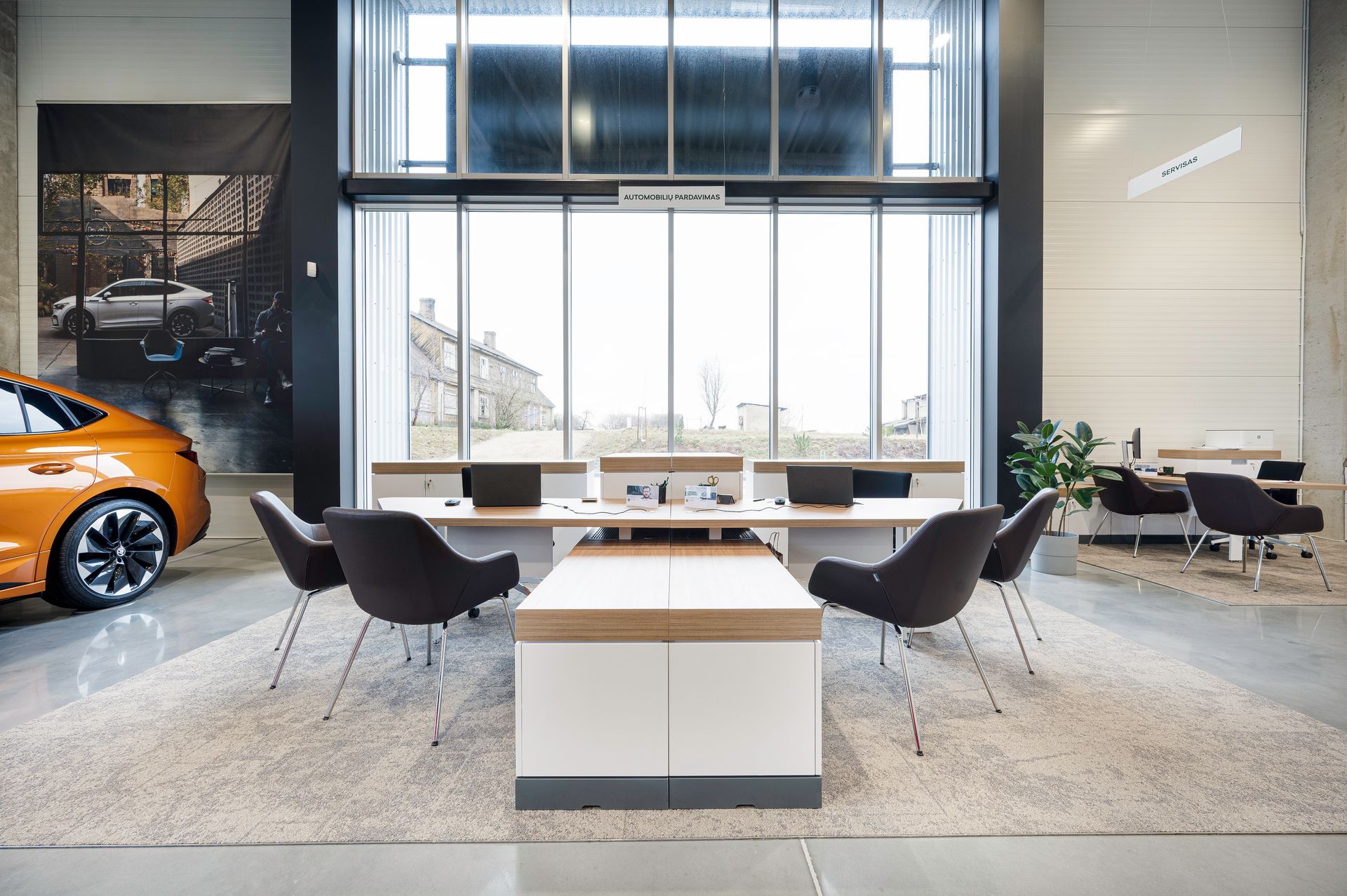Automobilis pastatytas salone prie stalo ir kėdžių.