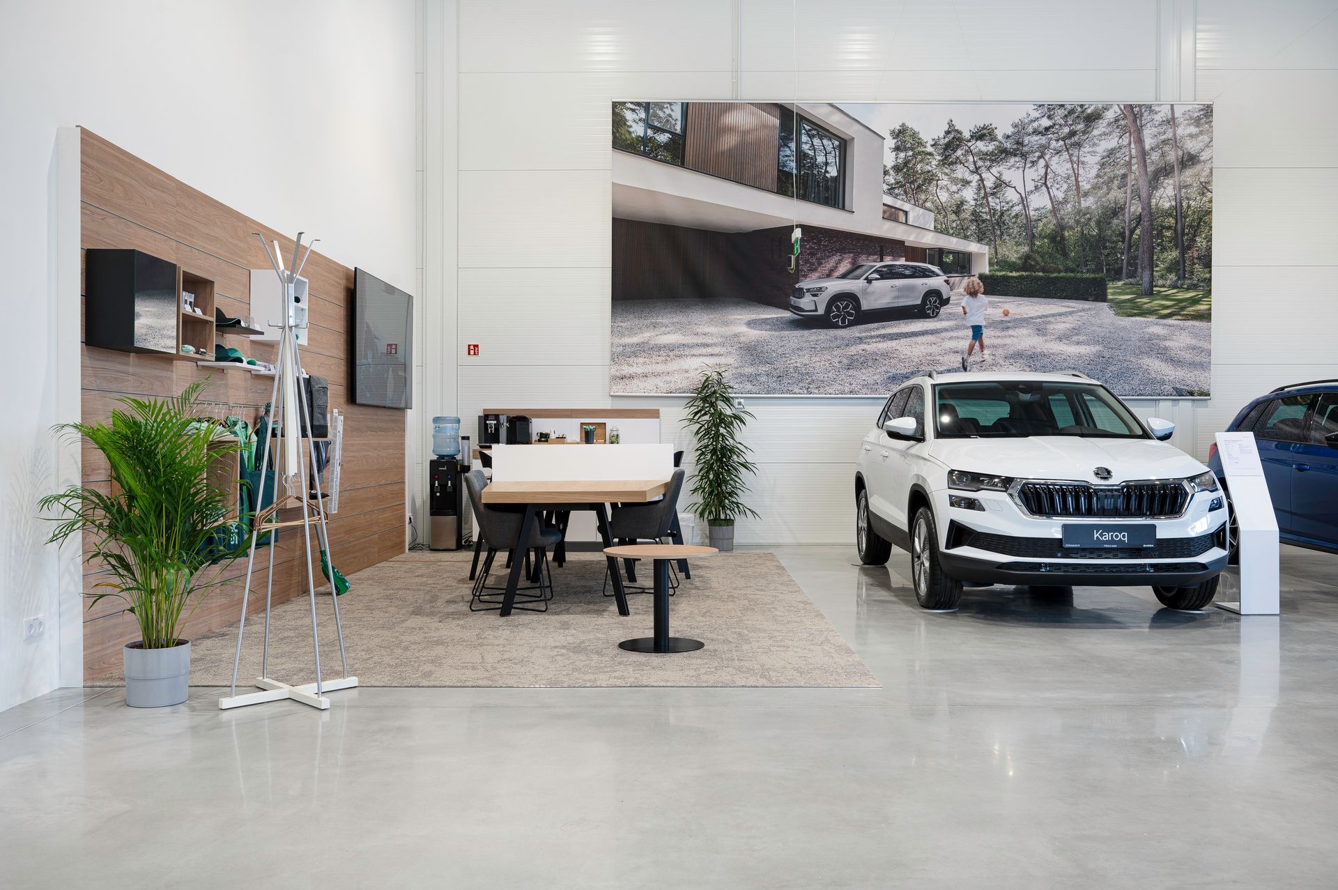 Automobilis pastatytas salone prie stalo ir kėdžių.