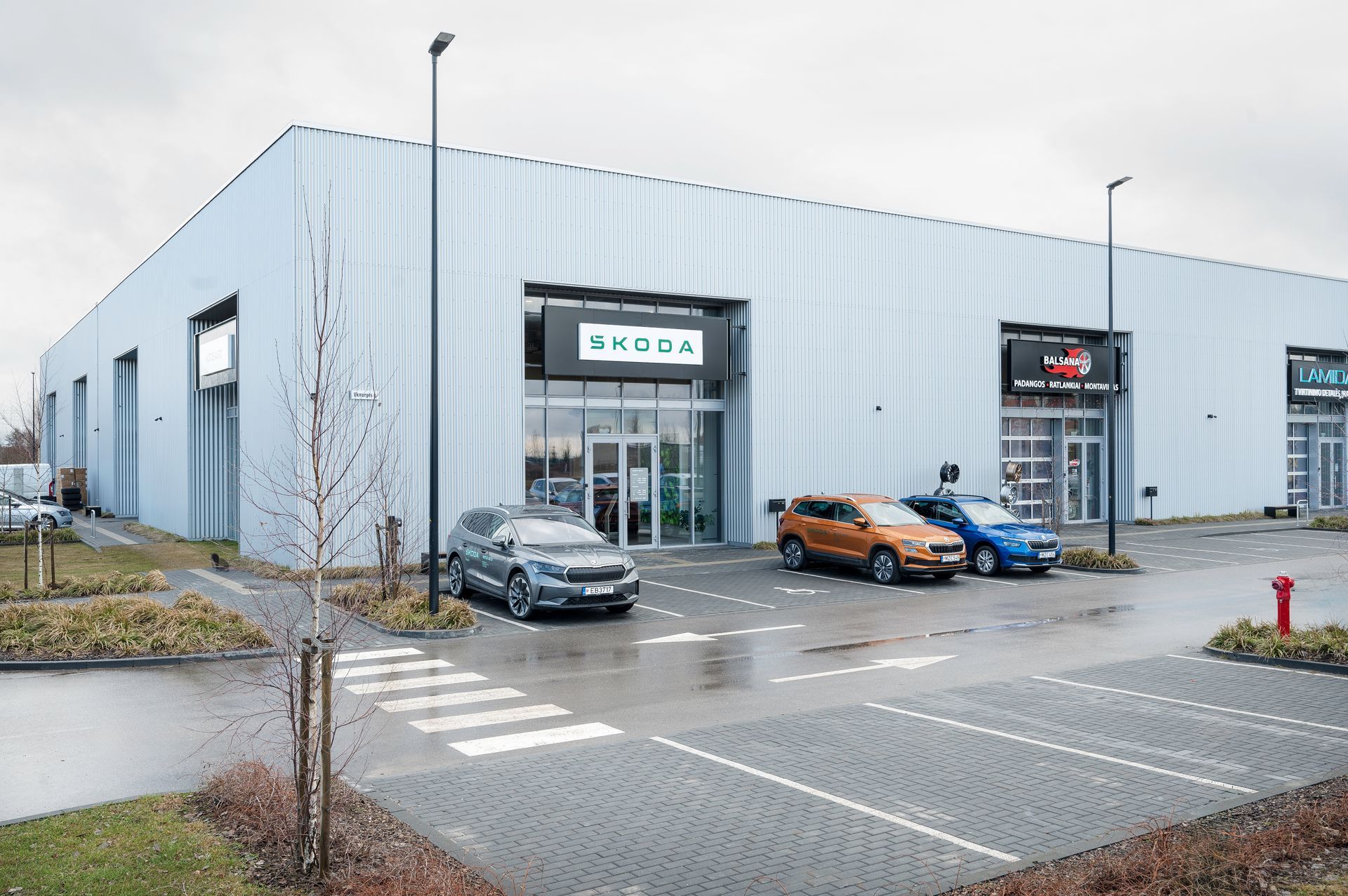 Automobilių prekybos atstovybė, priešais kurią pastatyti automobiliai.