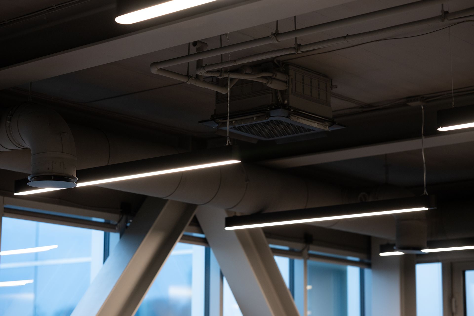 Interior ceiling with pipes, lights, and structural beams.