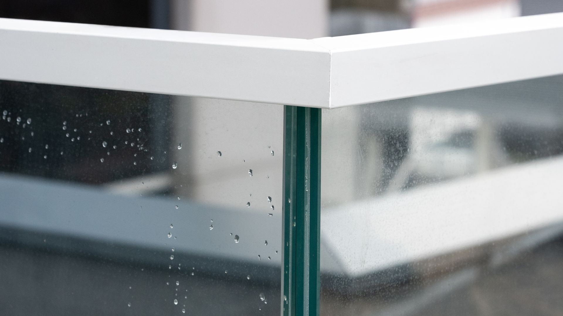 White-framed glass corner. Water droplets cling to the glass.