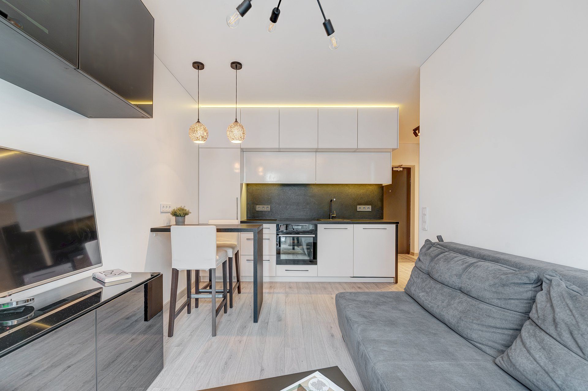 Svetainė su sofa ir plokščiaekraniu televizoriumi