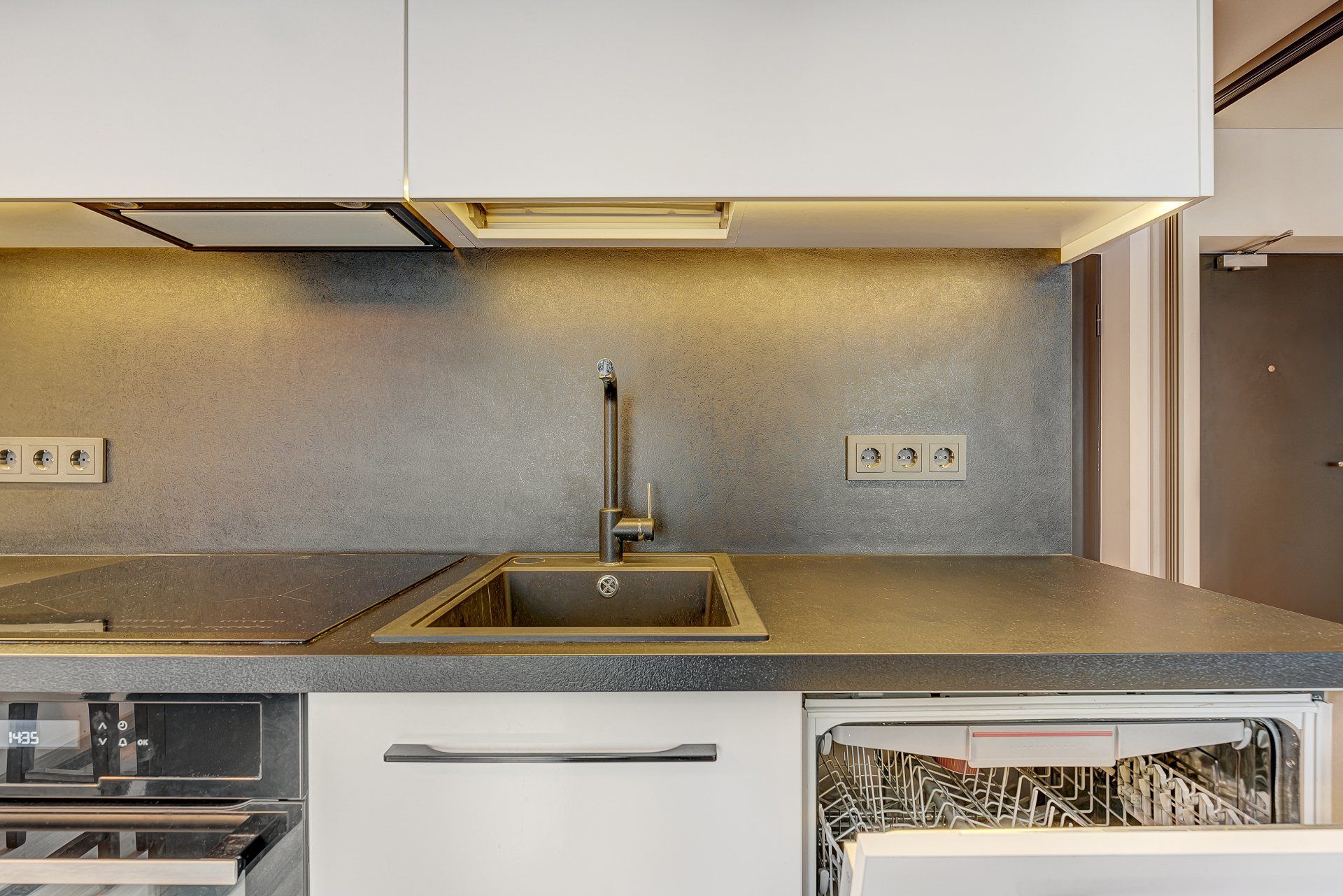 Virtuvė su kriaukle, virykle ir indaplove.