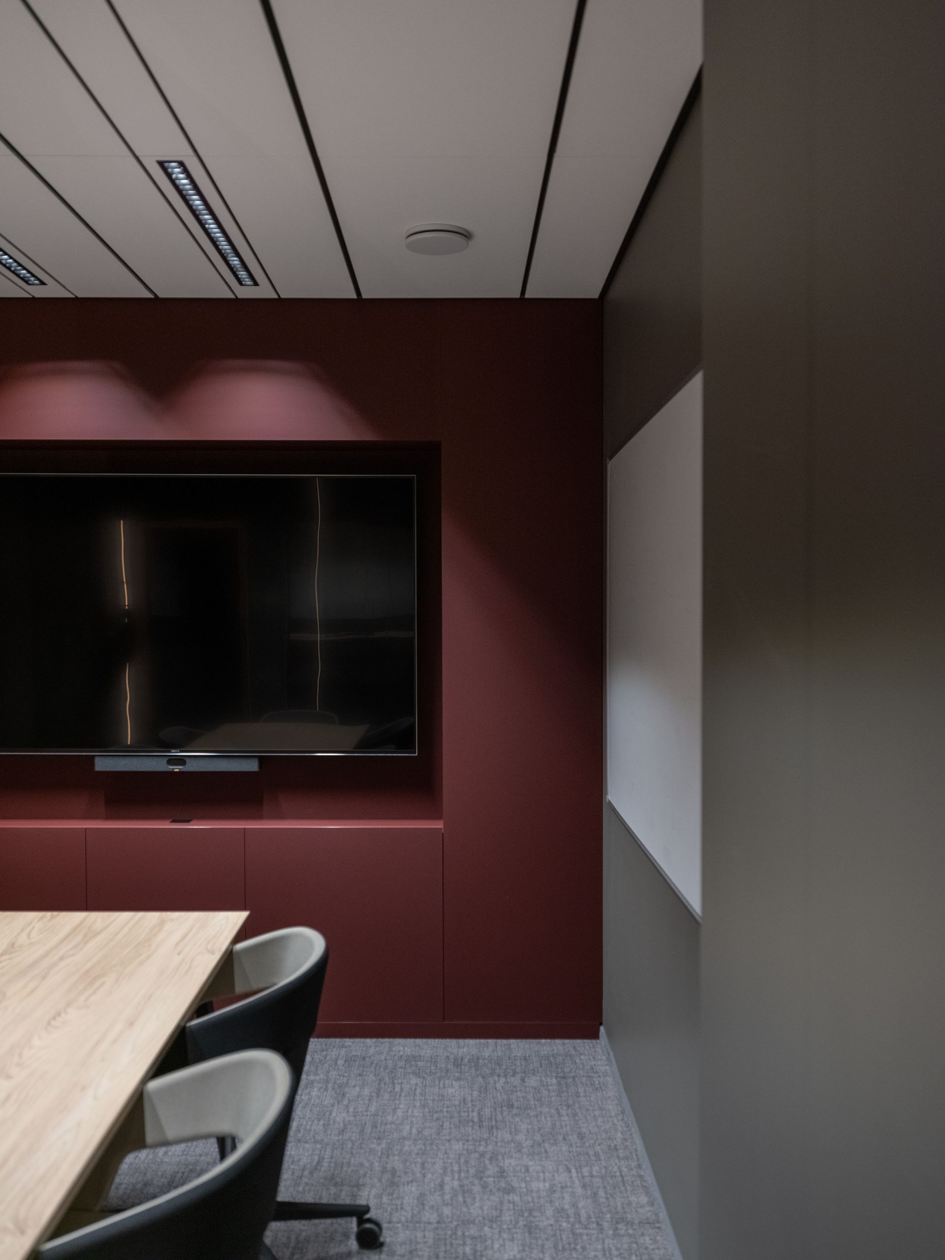 Konferencijų salė su dideliu plokščiaekraniu televizoriumi ant sienos