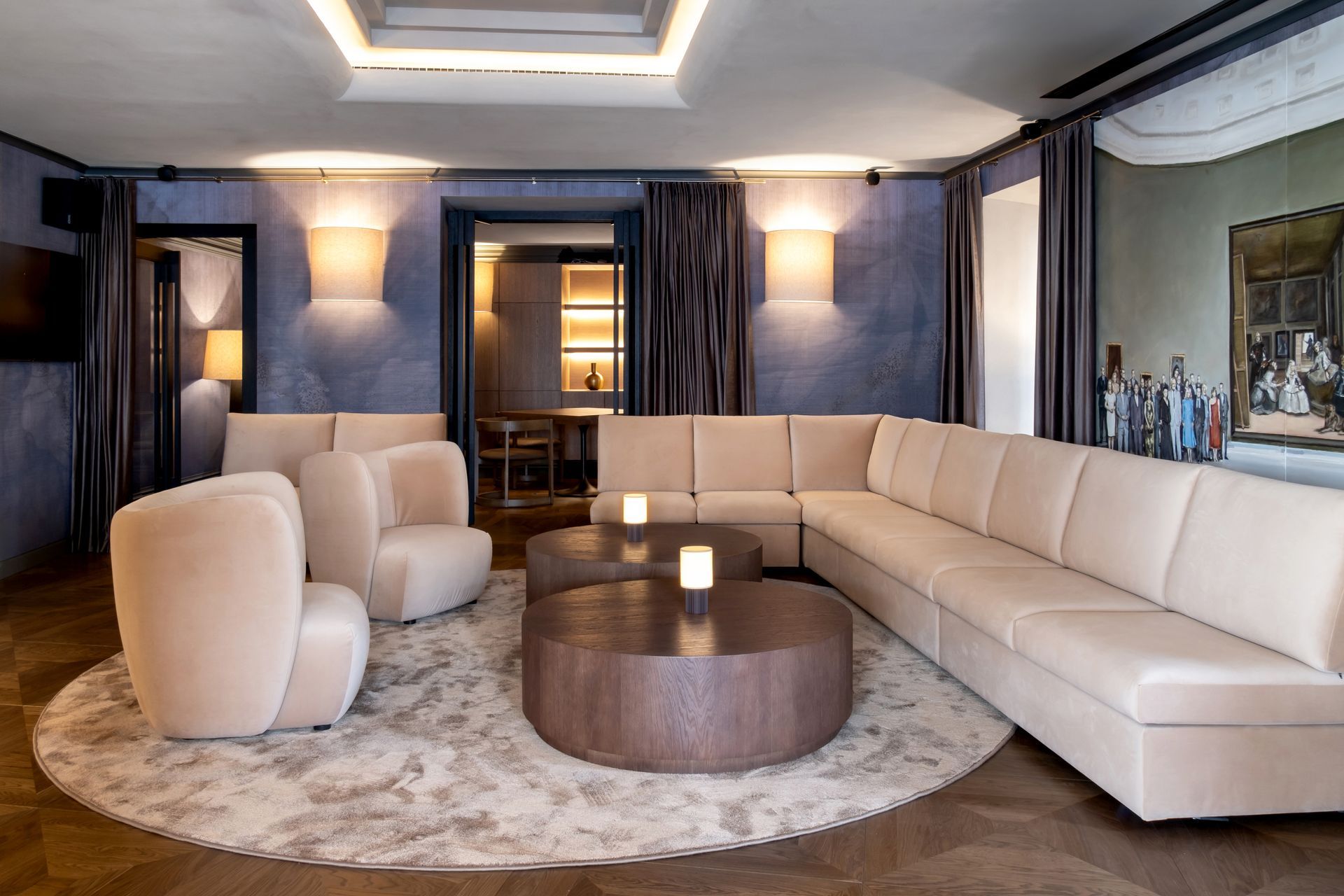 Svetainė su sofa, foteliais ir apvaliu kavos staliuku.