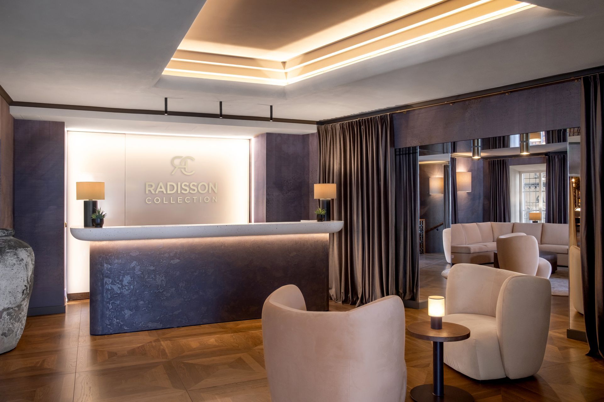 Viešbučio vestibiulis su registratūra ir kėdėmis