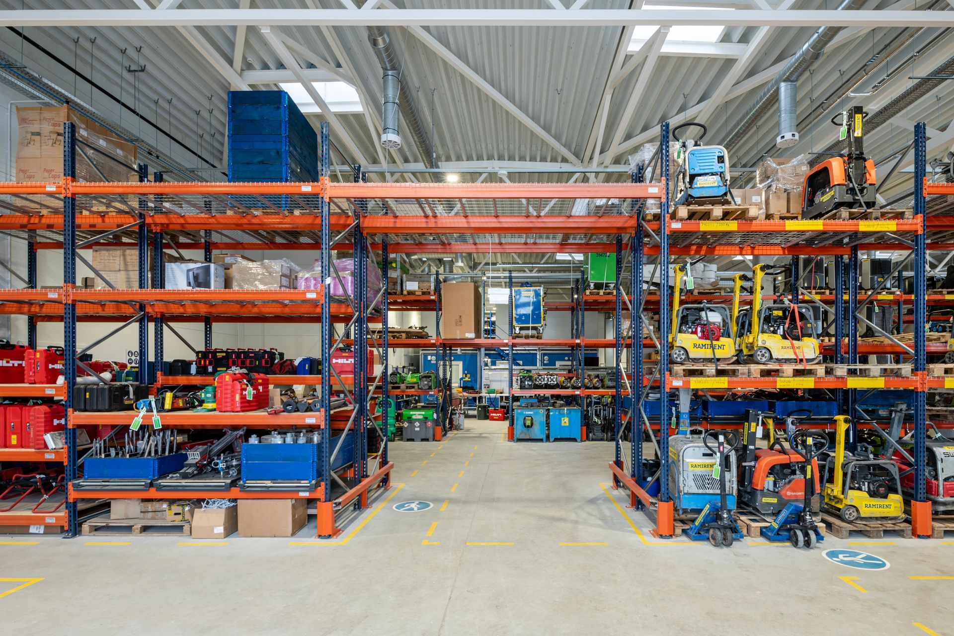 Didelis sandėlis, pilnas lentynų ir mechanizmų.