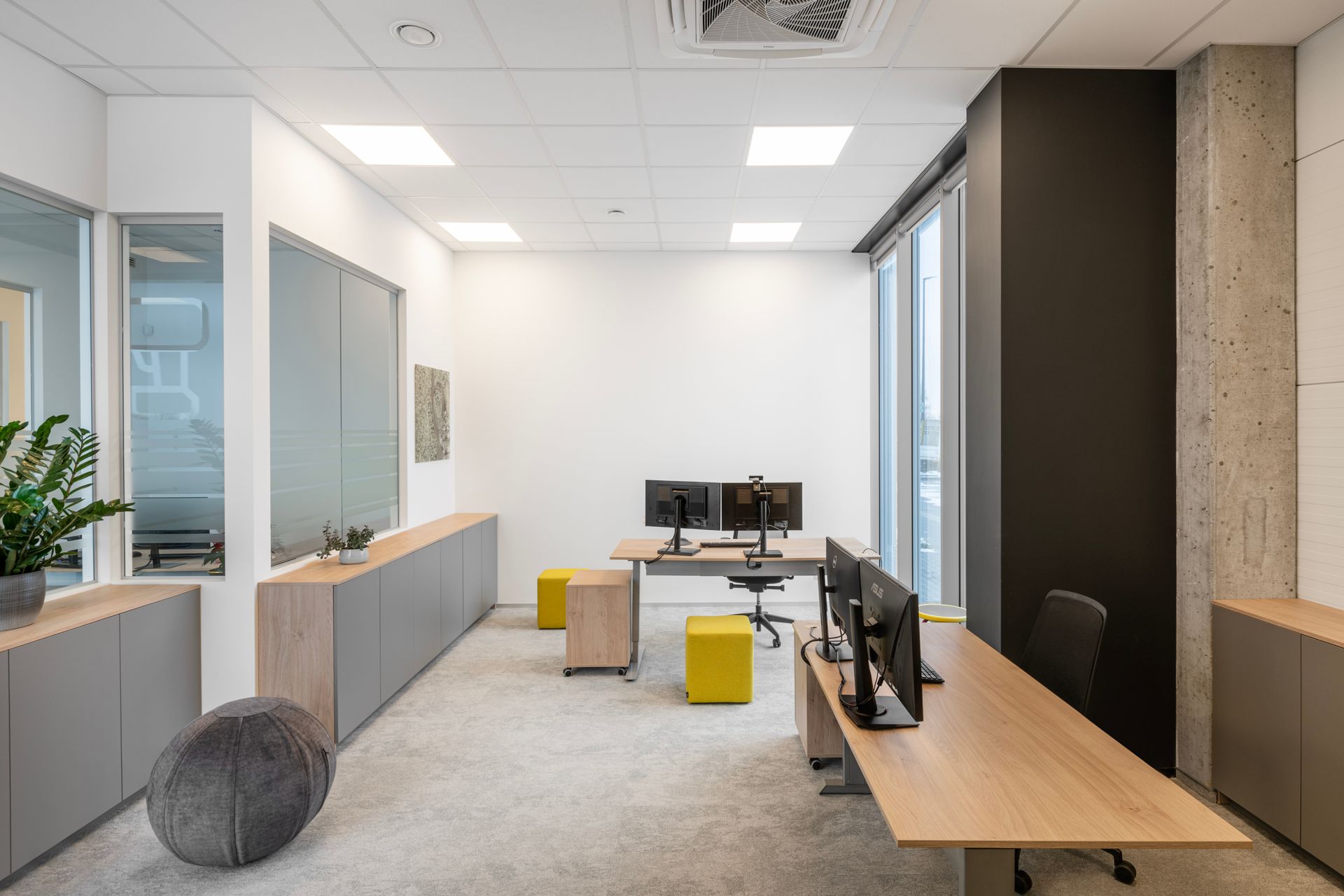 Kambarys su dviem stalais ir dviem kompiuterių monitoriais.