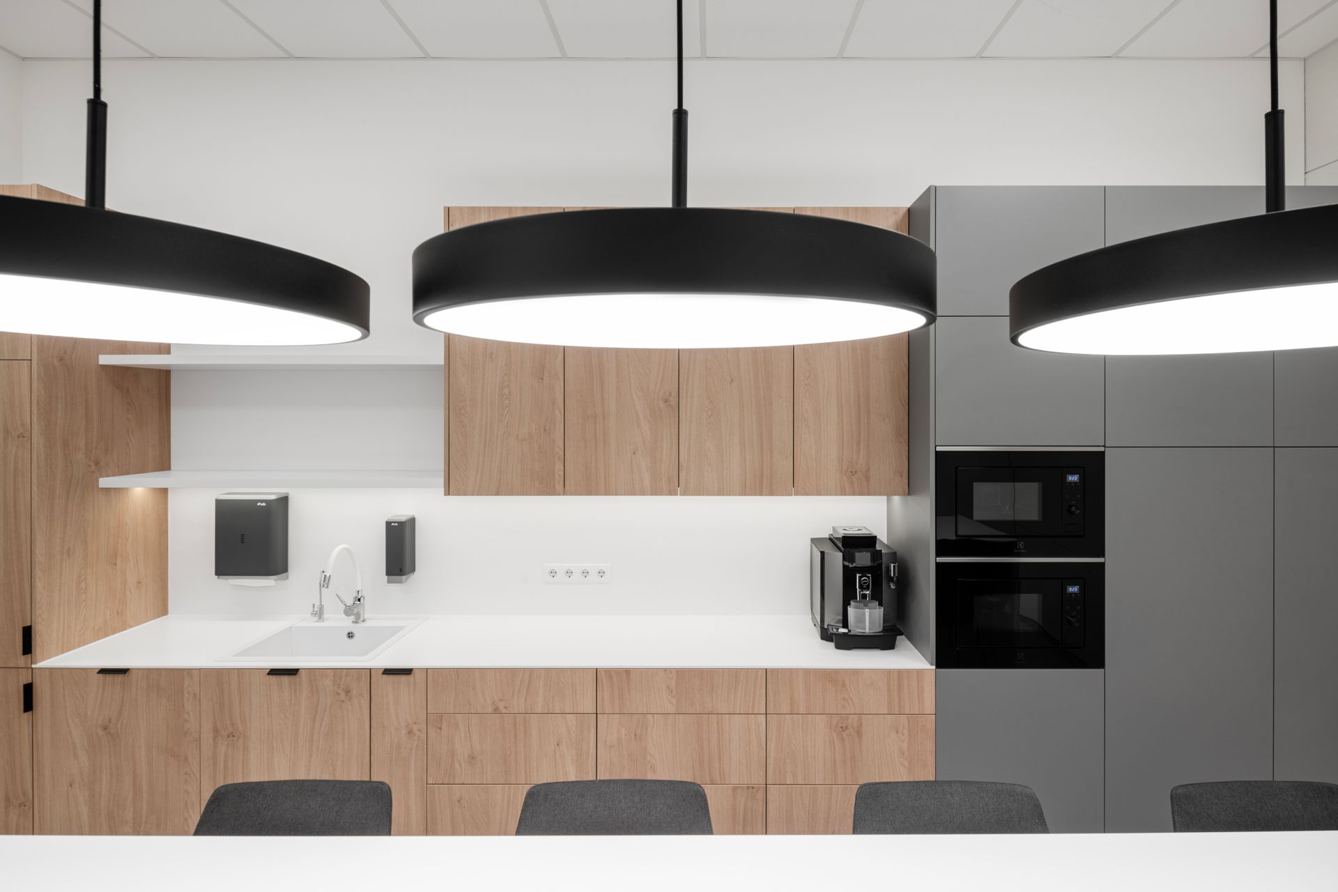 Virtuvė su medinėmis spintelėmis ir mikrobangų krosnele