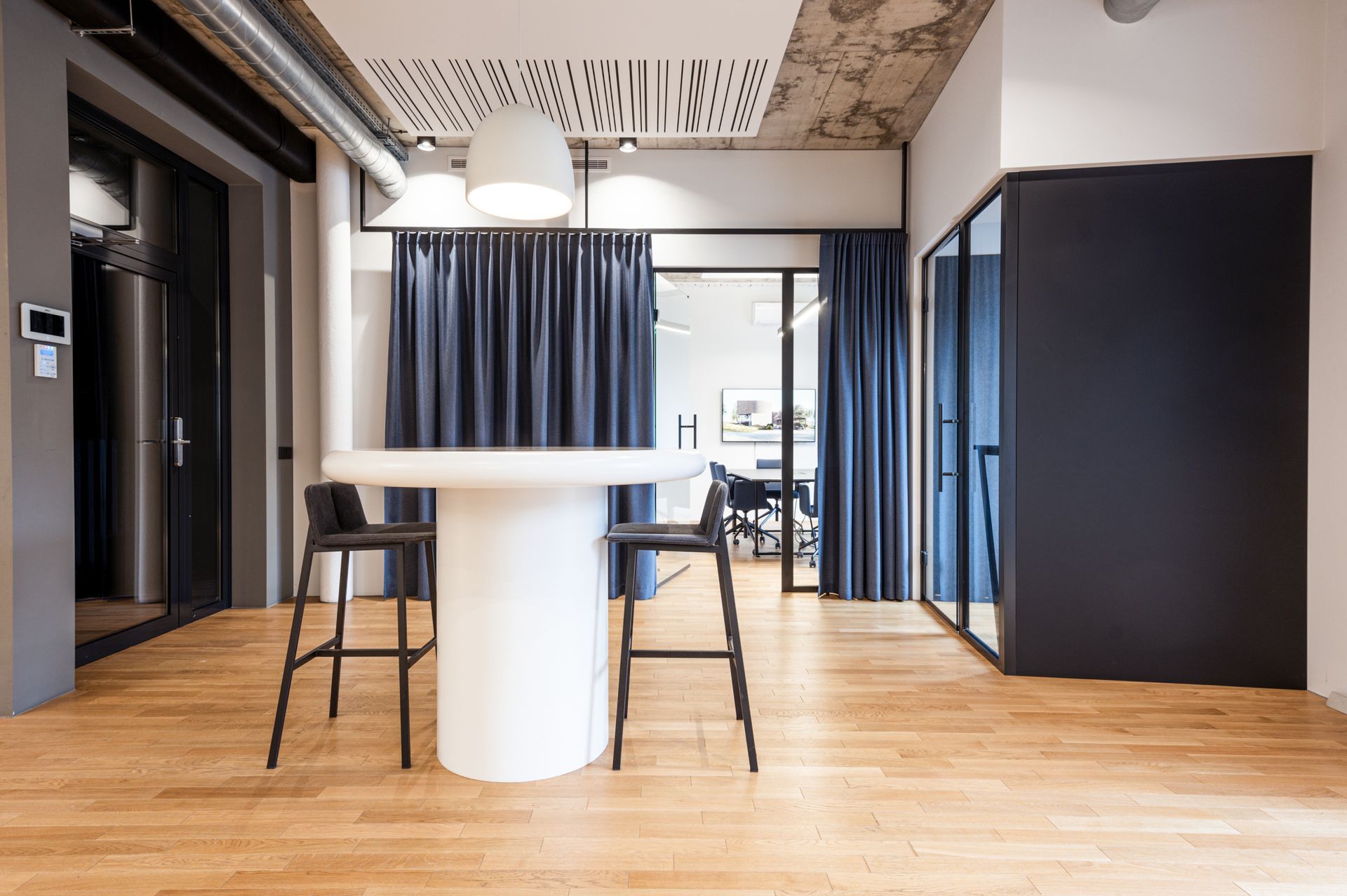 Kambarys su stalu ir taburetėmis jame.