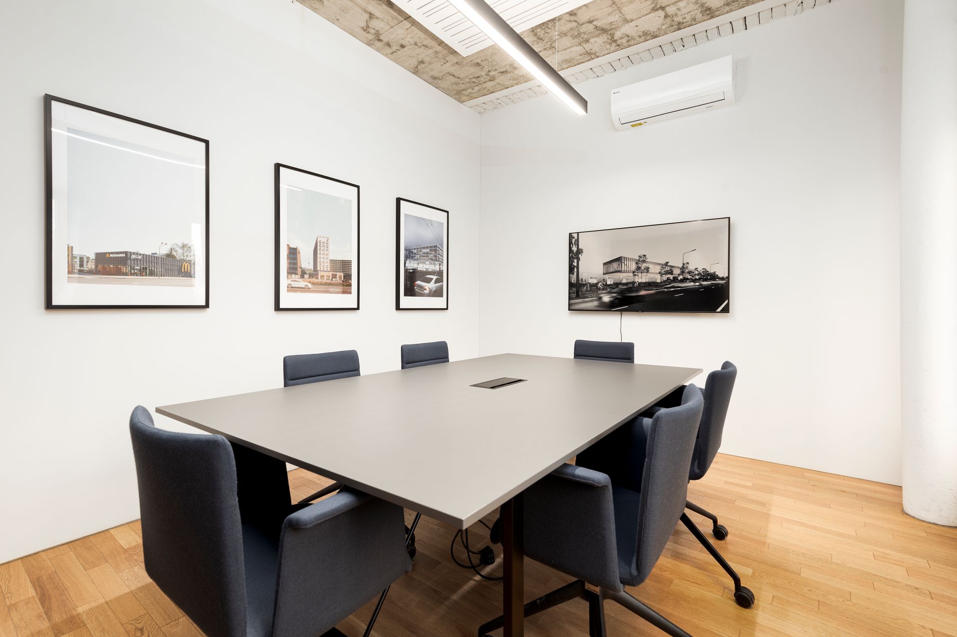 Konferencijų salė su ilgu stalu ir kėdėmis.