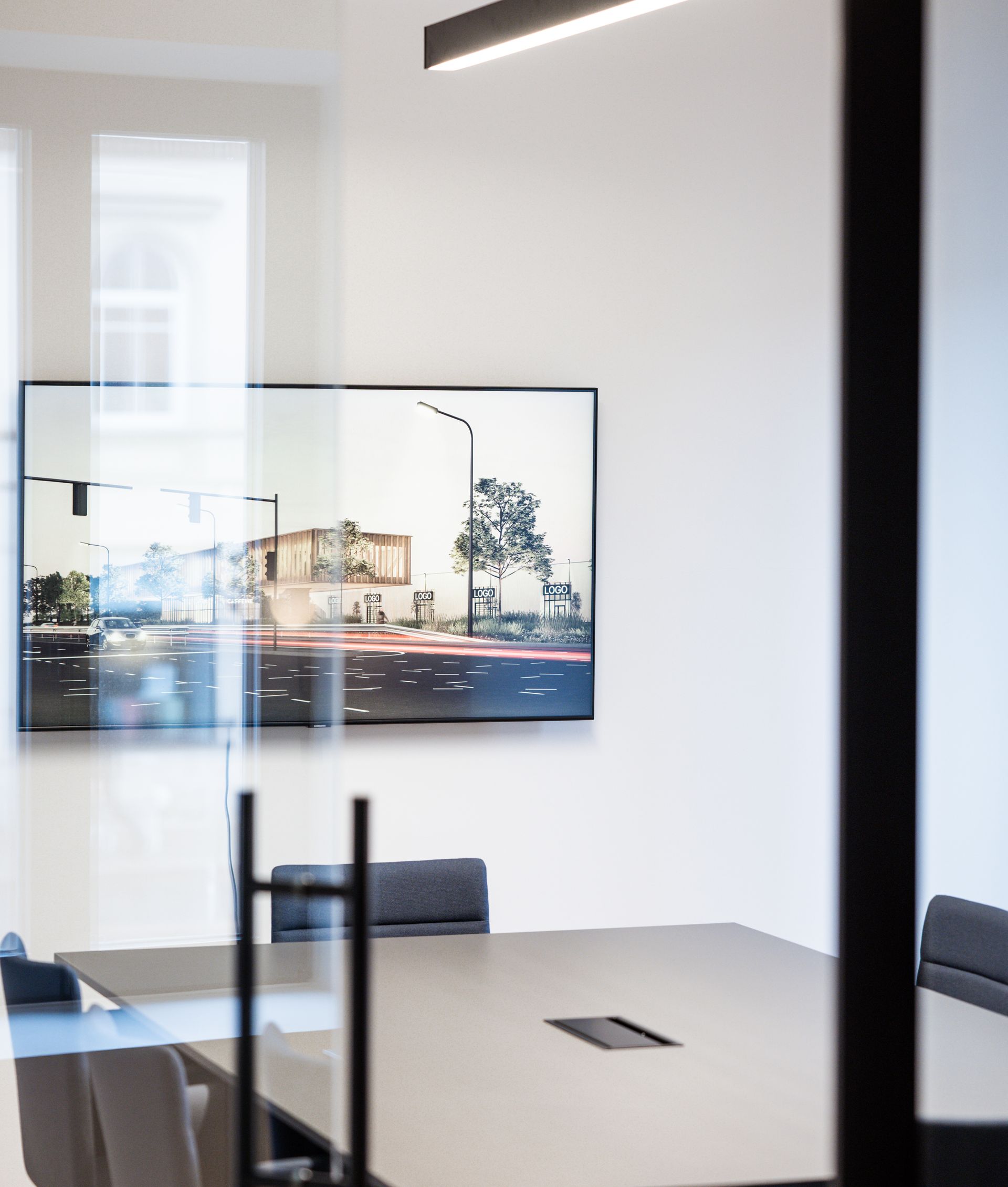 Konferencijų salė su paveikslu ant sienos virš stalo