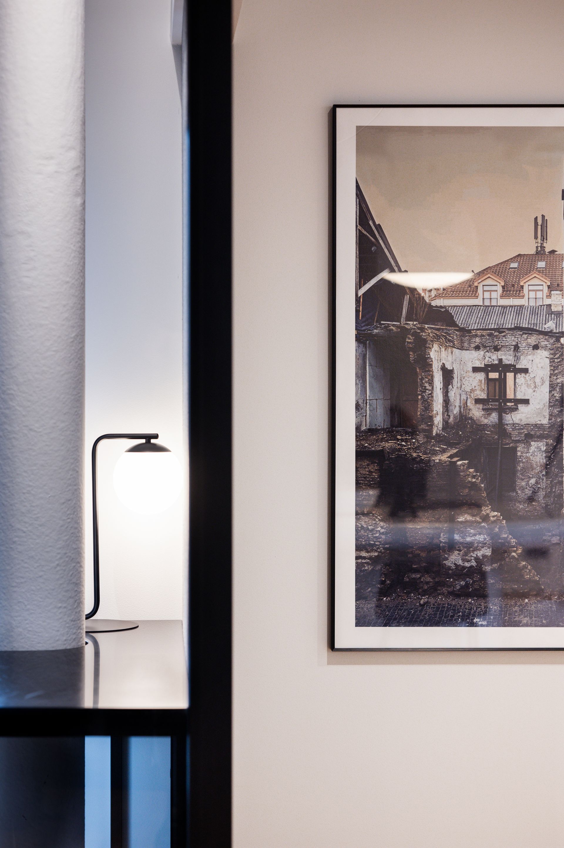 Ant sienos šalia lempos kabo pastato paveikslas.