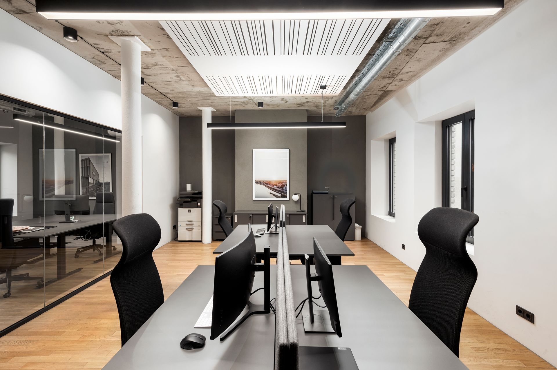 Didelis biuras su daugybe stalų ir kėdžių