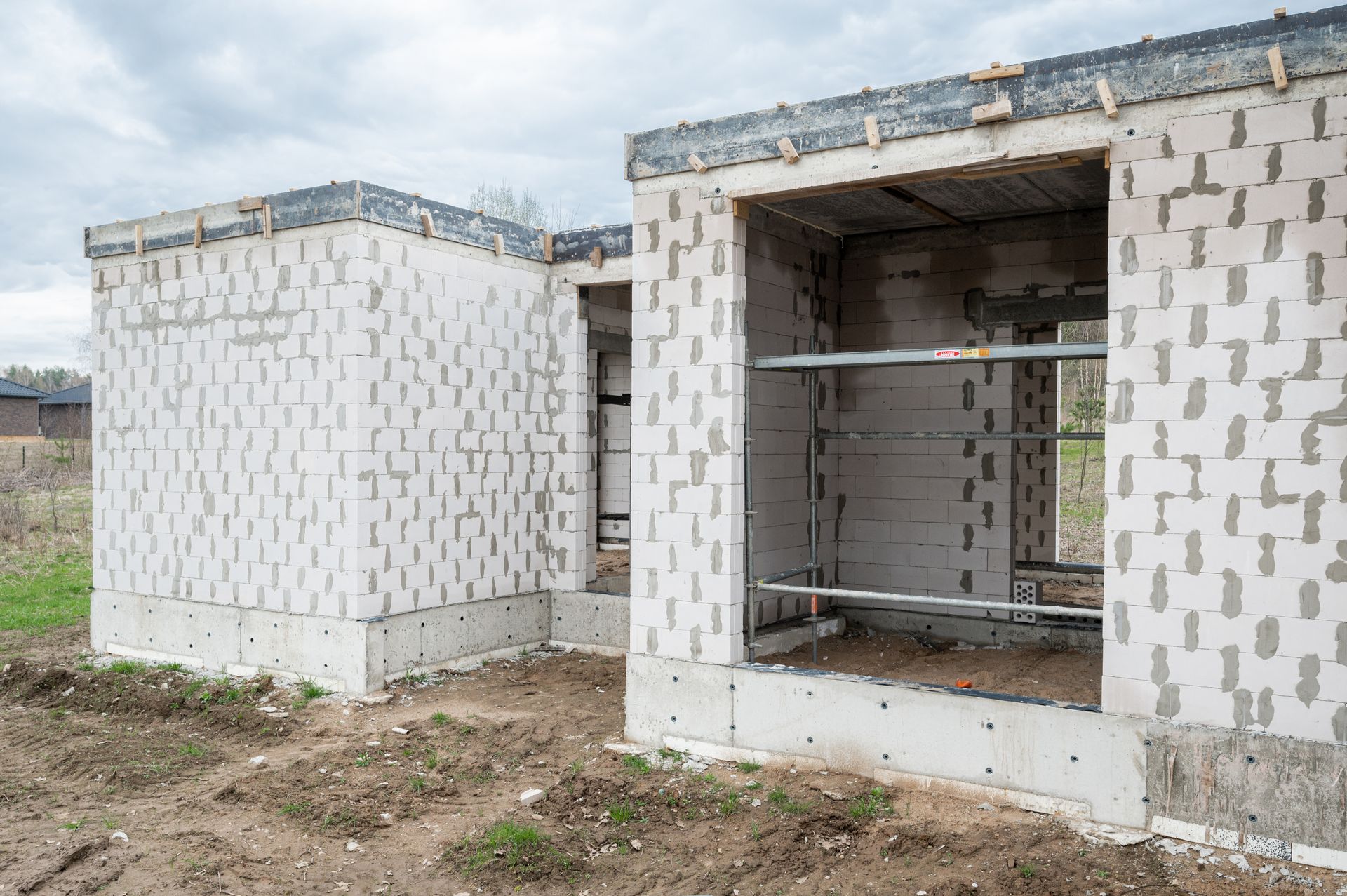 Namas statomas iš plytų ir pastolių.