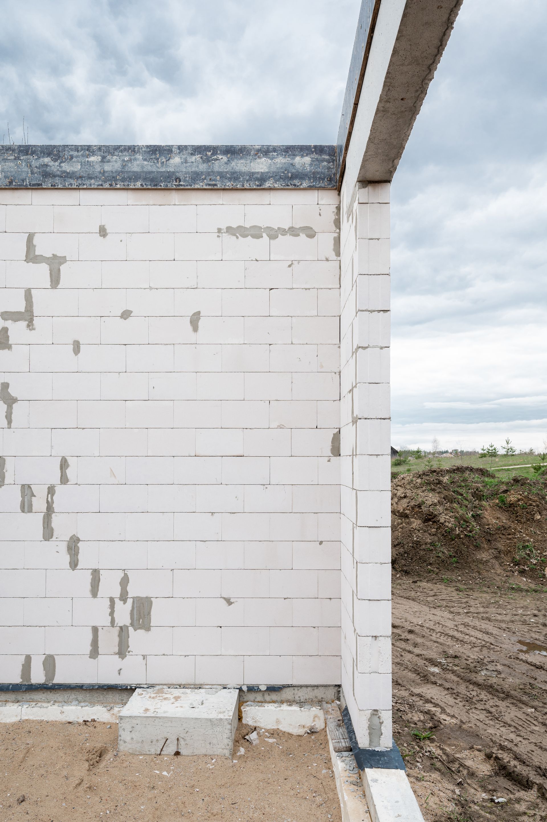 Statybvietėje statoma baltų plytų siena.