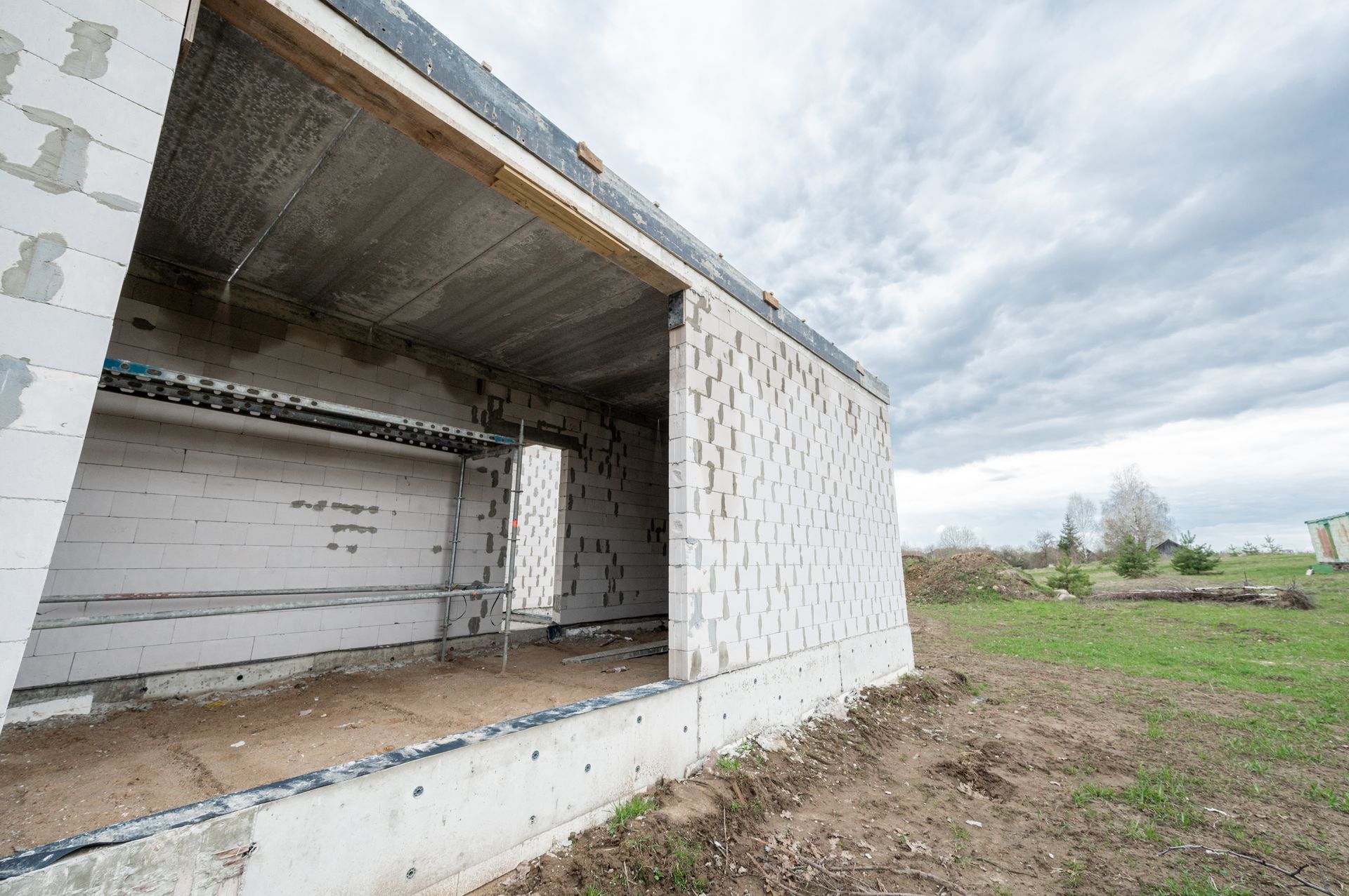 Lauke statomas baltų plytų pastatas.