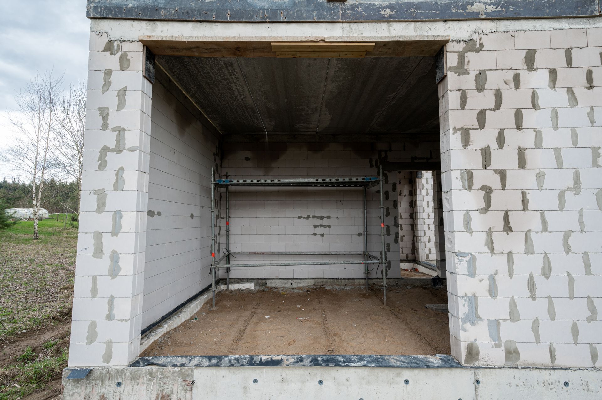 Tuščias statomas garažas su atidarytomis durimis.