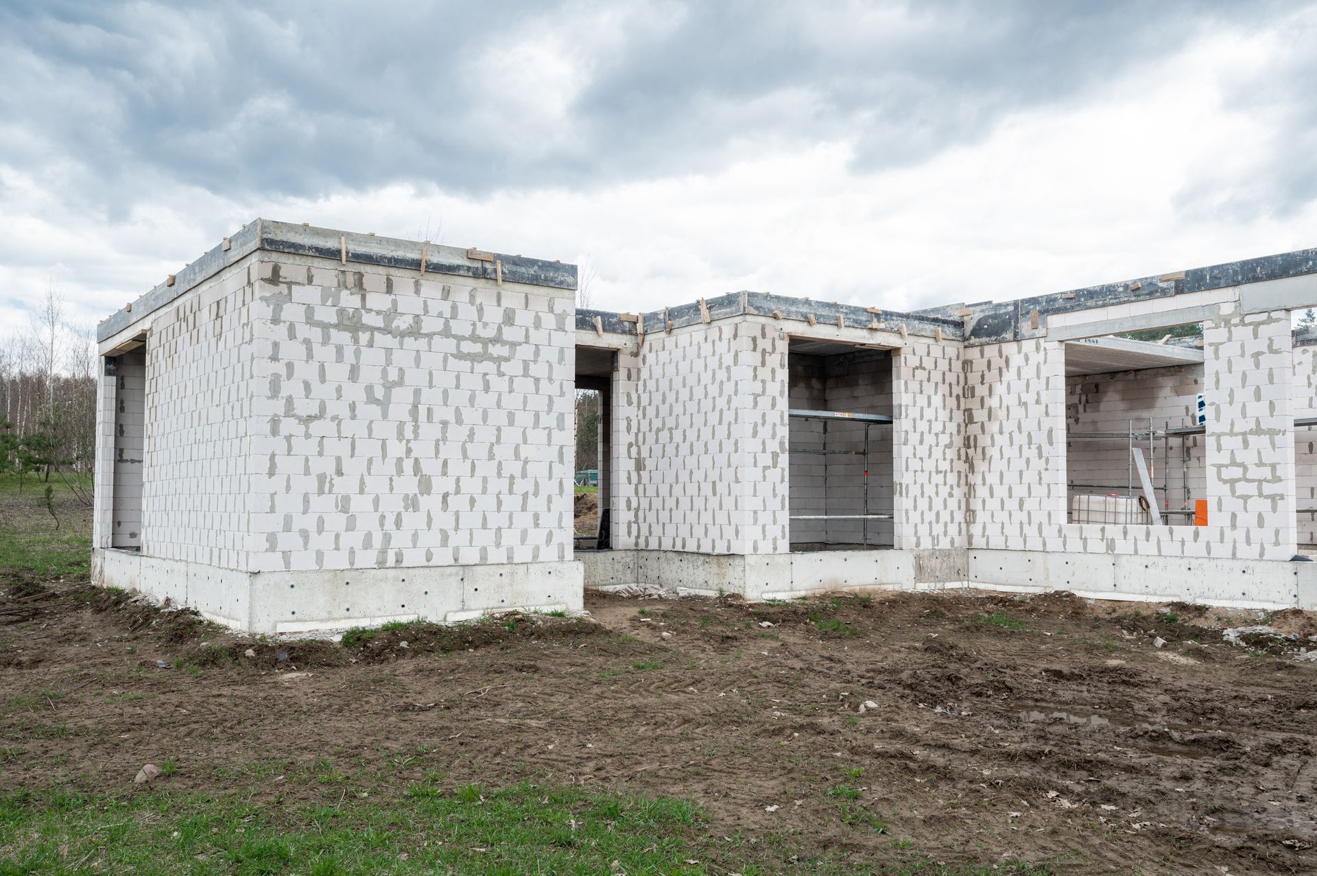 Lauke statomas baltų plytų namas.