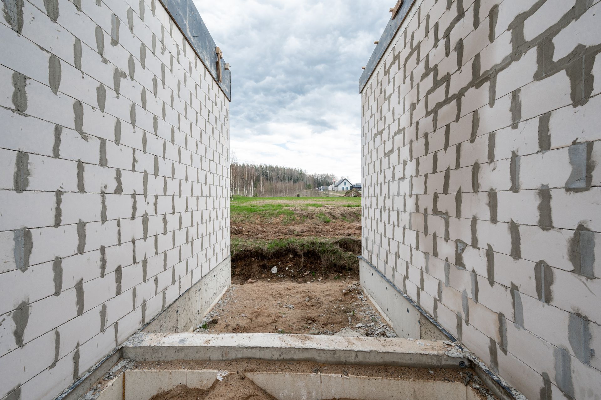 Baltų plytų siena su skyle viduryje.