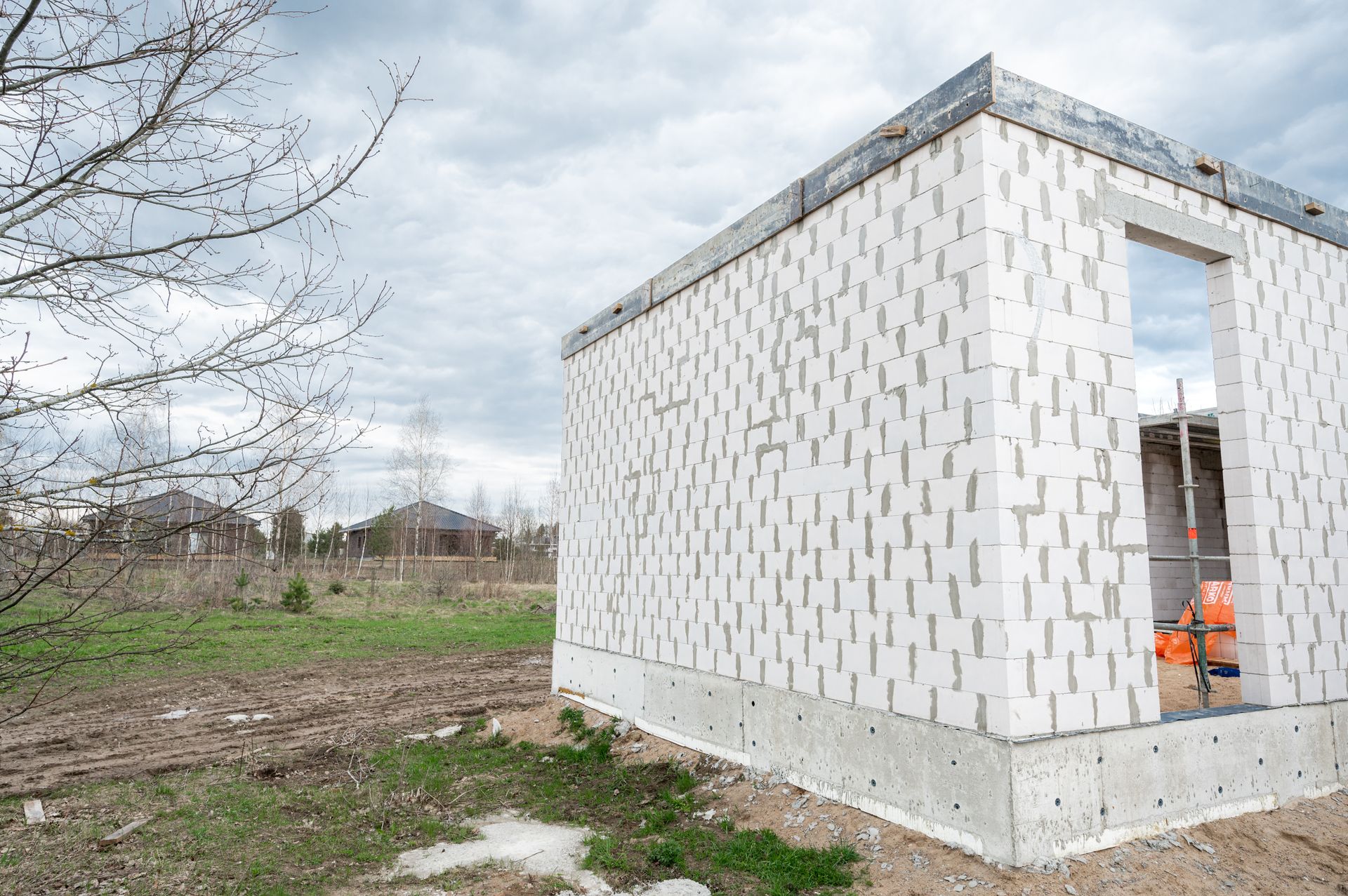 Lauke statomas baltų plytų namas.