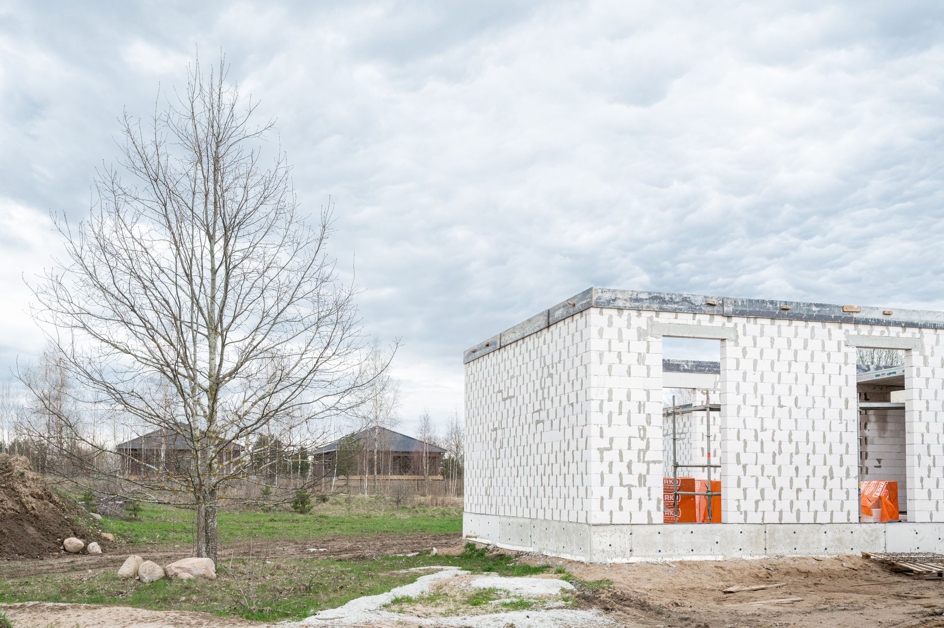 Lauke statomas baltas namas, fone – medis.