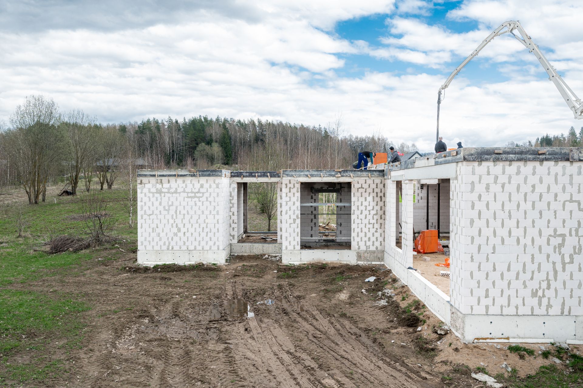 Lauke su betono siurbliu statomas namas.