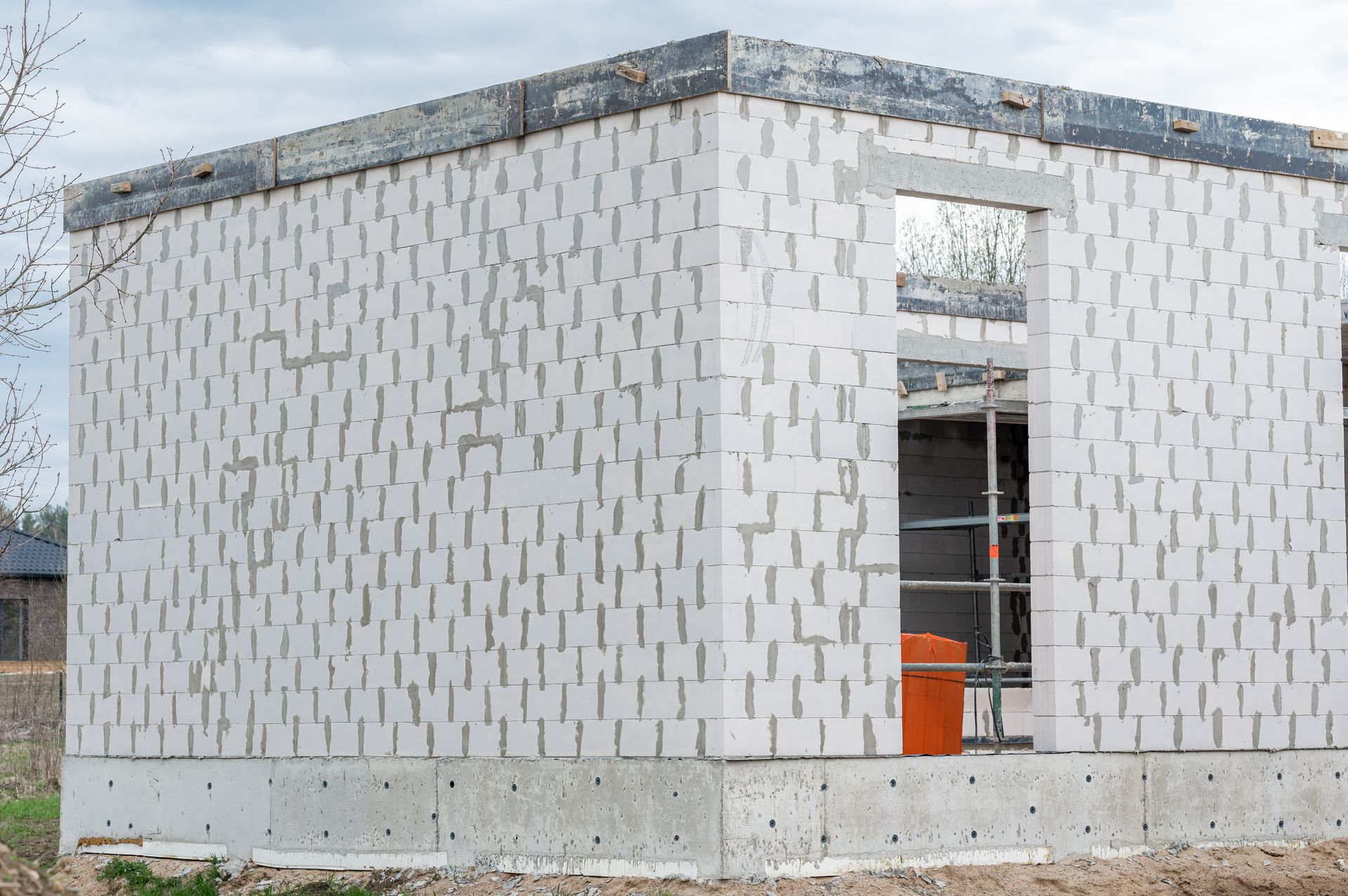 Statybvietėje statomas baltų plytų namas.