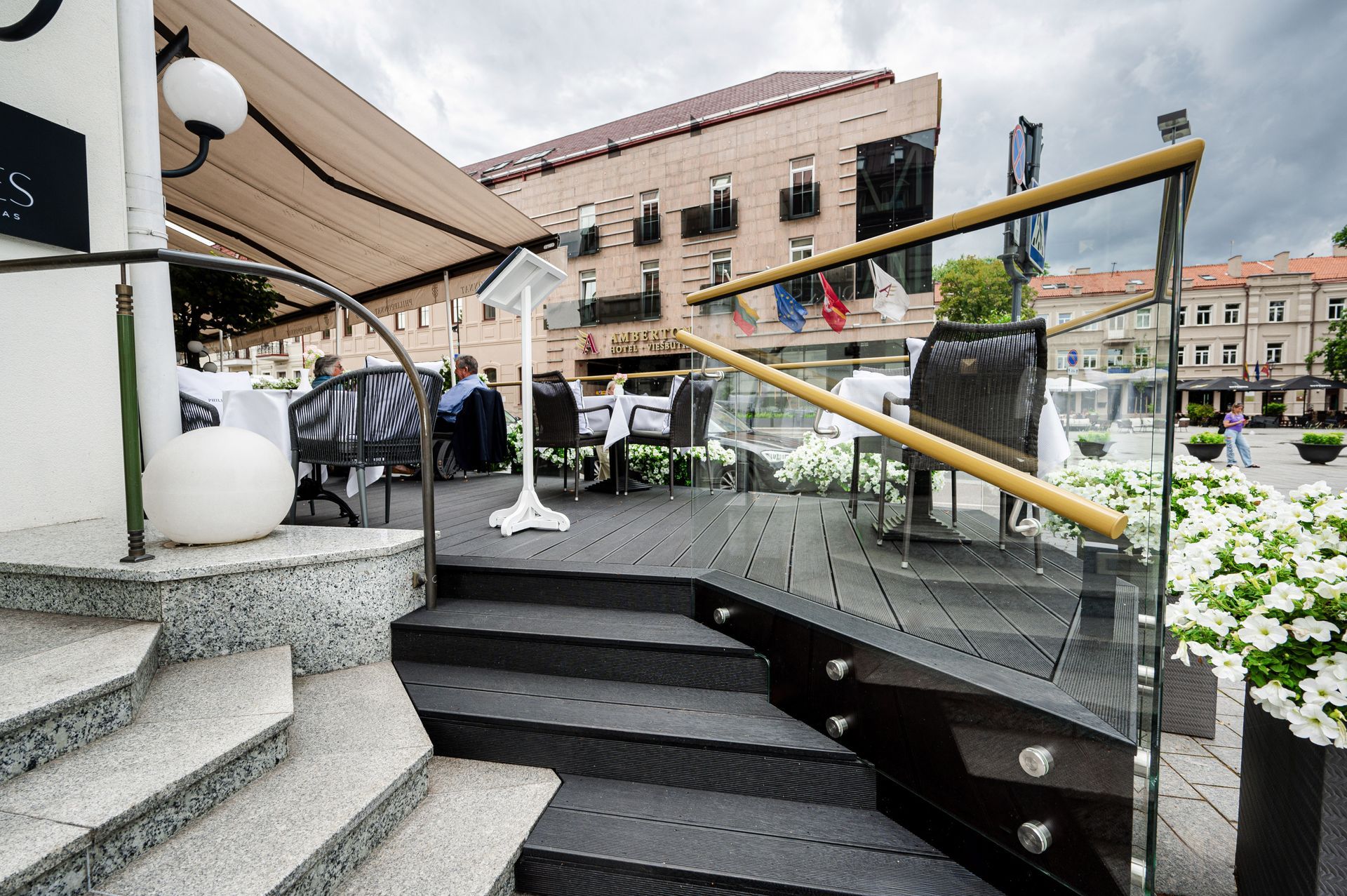 Laiptai, vedantys į restoraną su stikliniais turėklais.