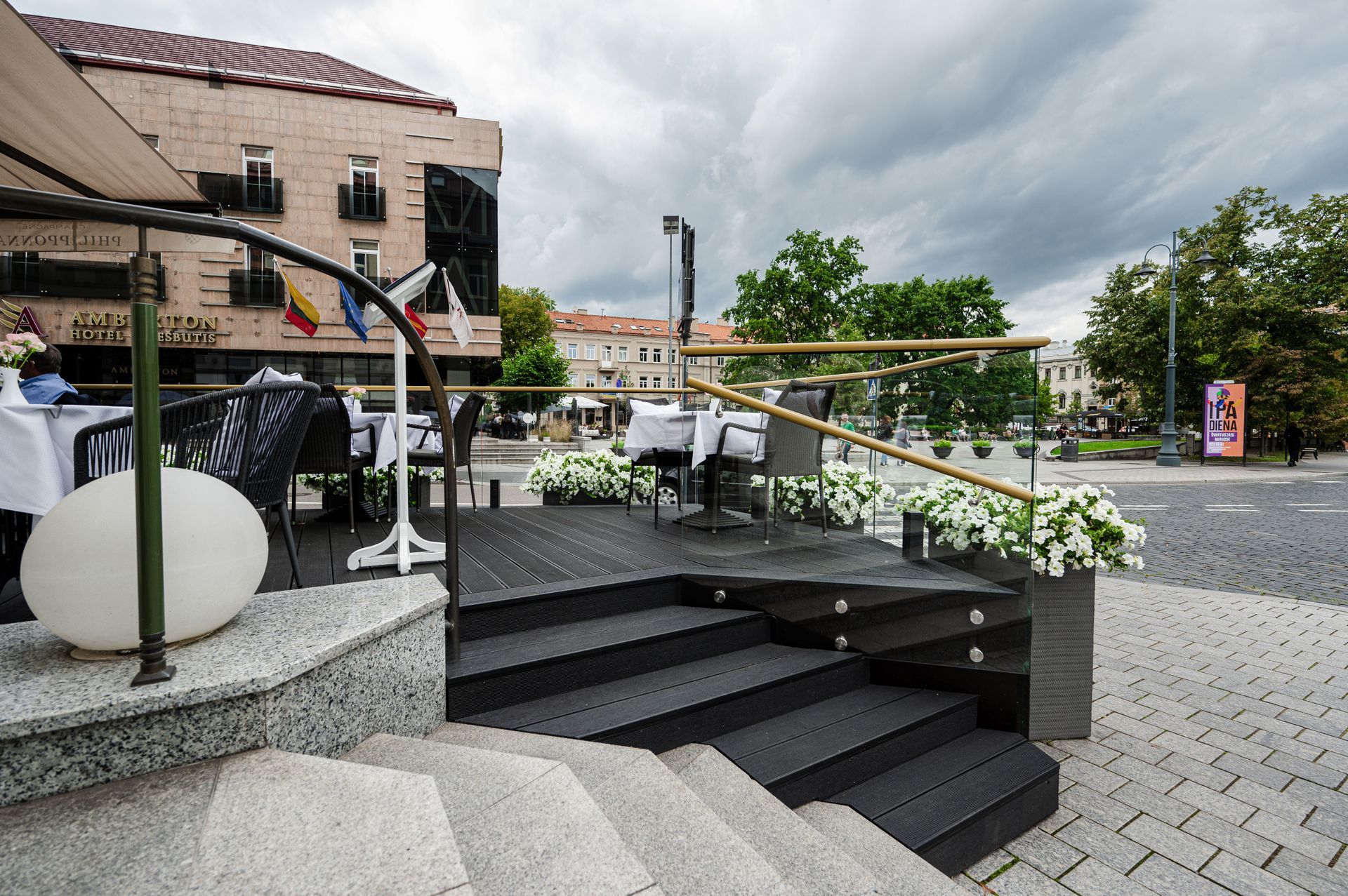 Laiptai, vedantys į restoraną su stalais ir kėdėmis