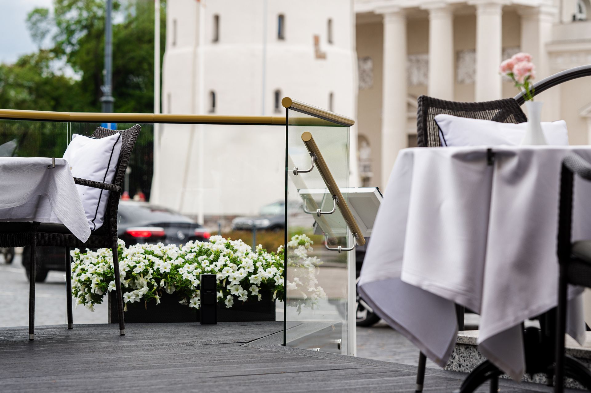 Lauke priešais pastatą stovi stalas su balta staltiese.