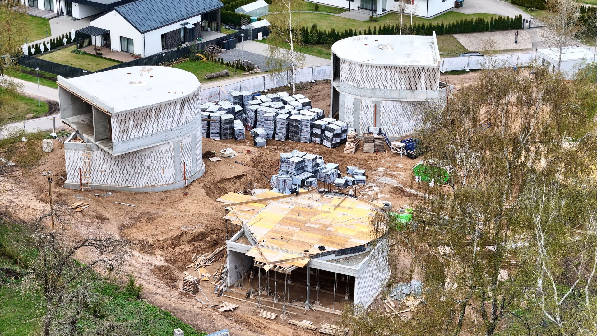 Gyvenamajame rajone statomo pastato vaizdas iš oro.