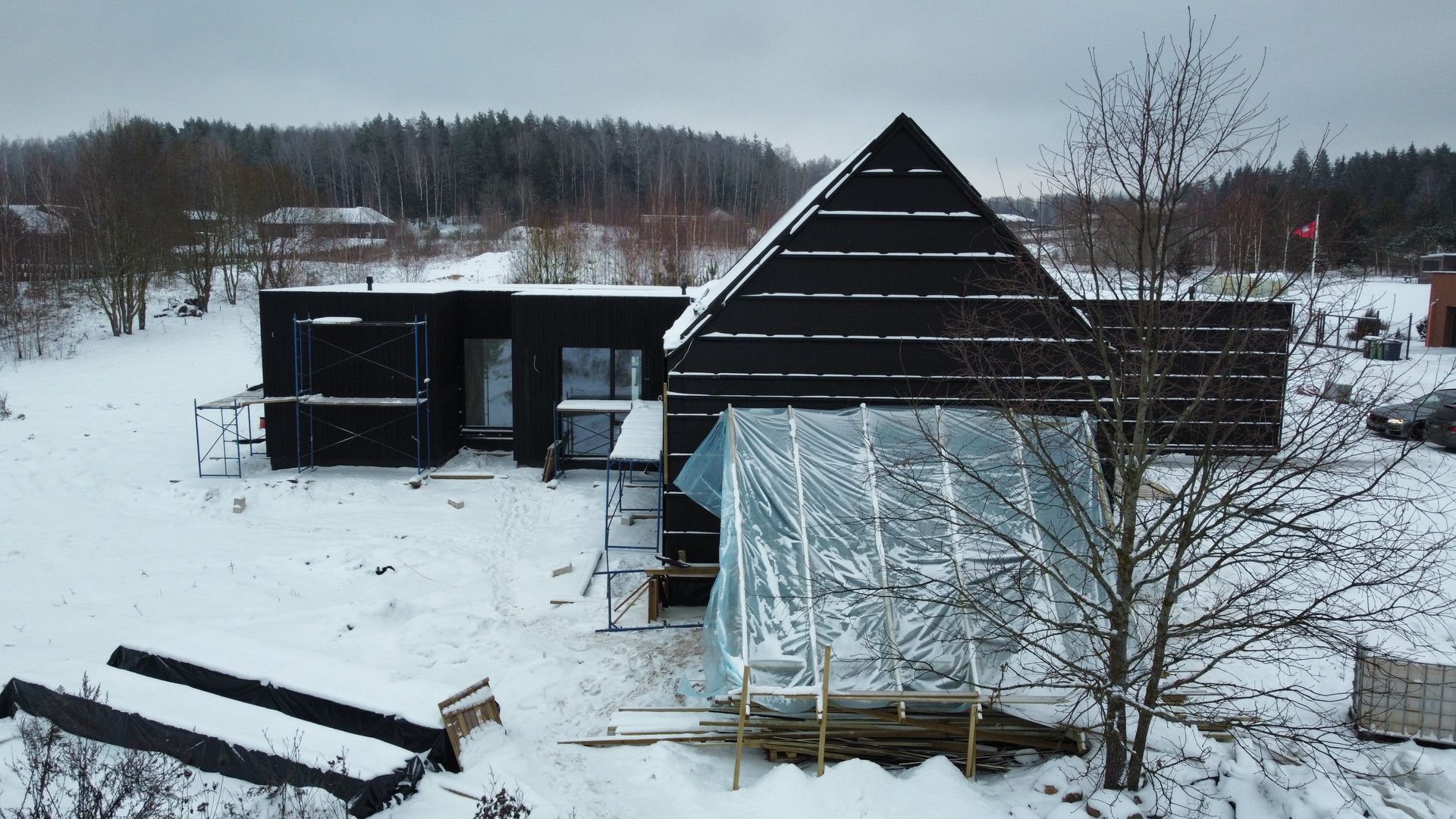 Vaizdas iš oro, kuriame namas statomas sniege