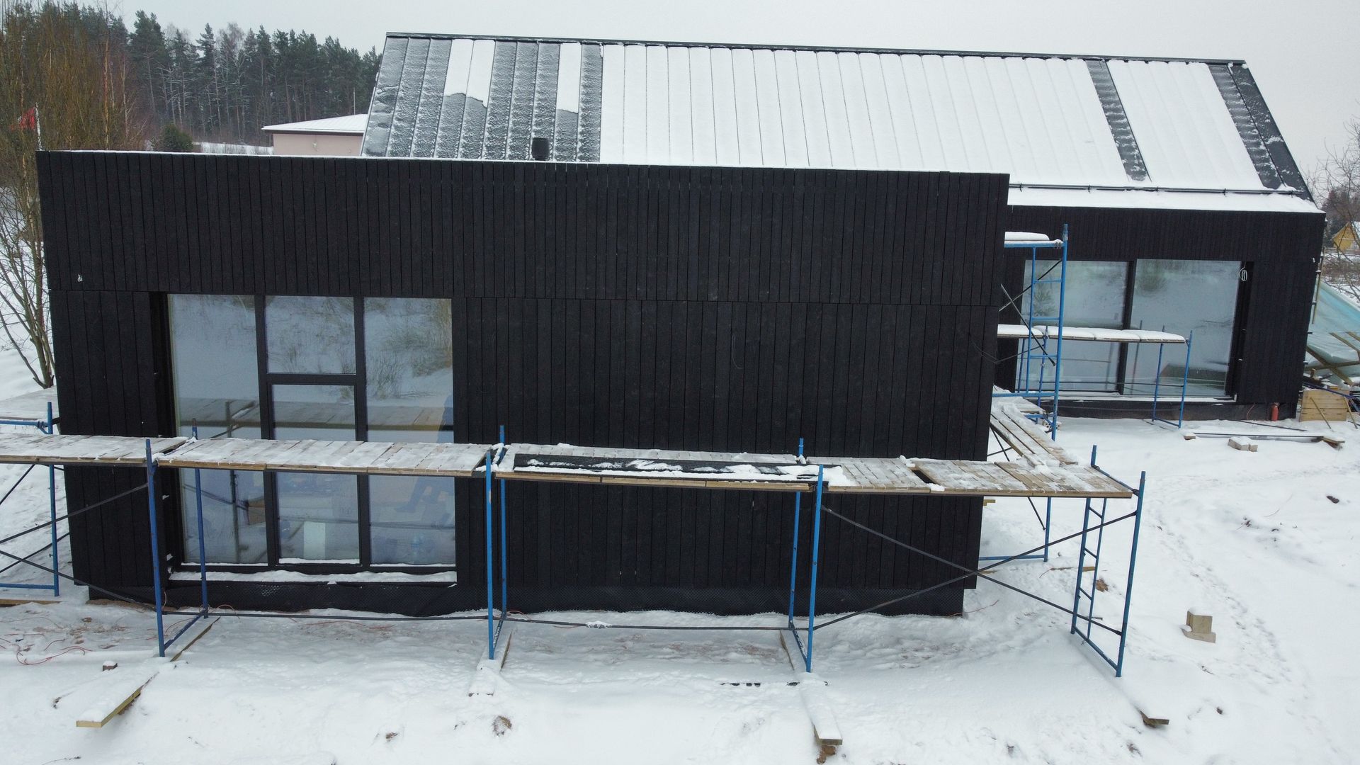 Sniege statomas didelis juodas namas.