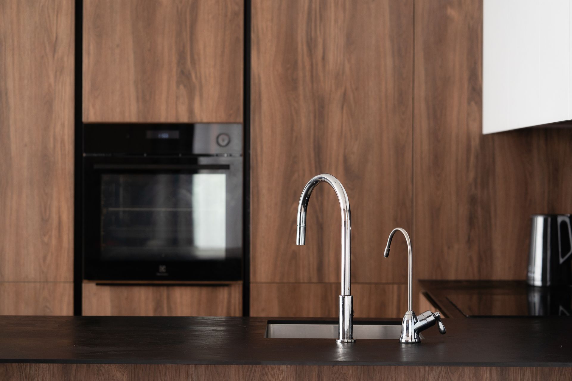 Virtuvė su kriaukle, orkaite ir mikrobangų krosnele.