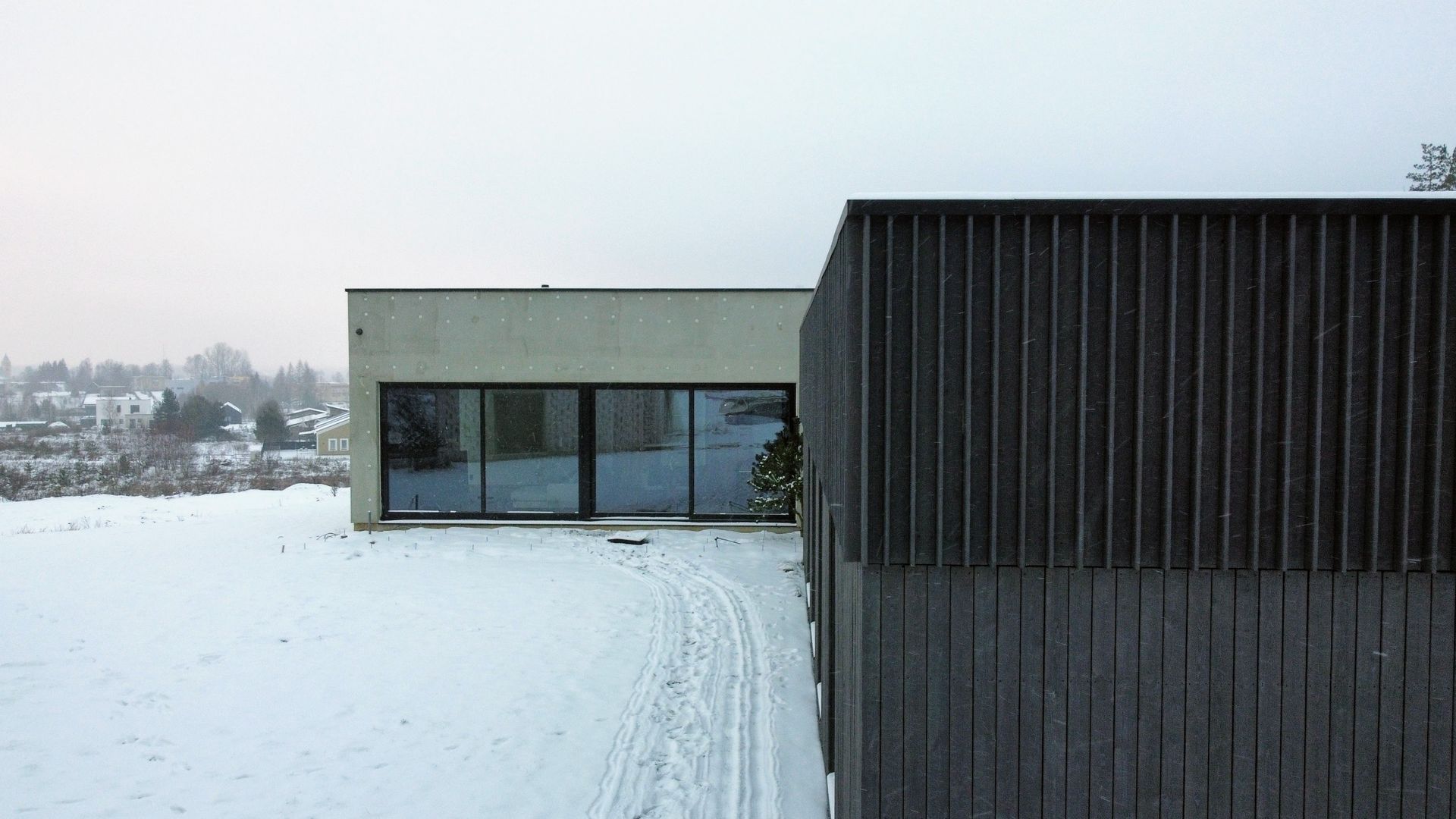 Namas stovi sniegu padengto lauko viduryje.