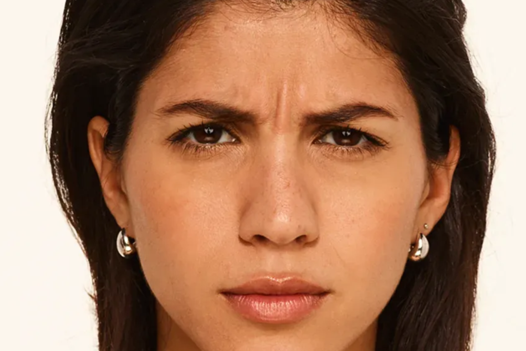 Close-up of a woman with a serious expression against a plain background